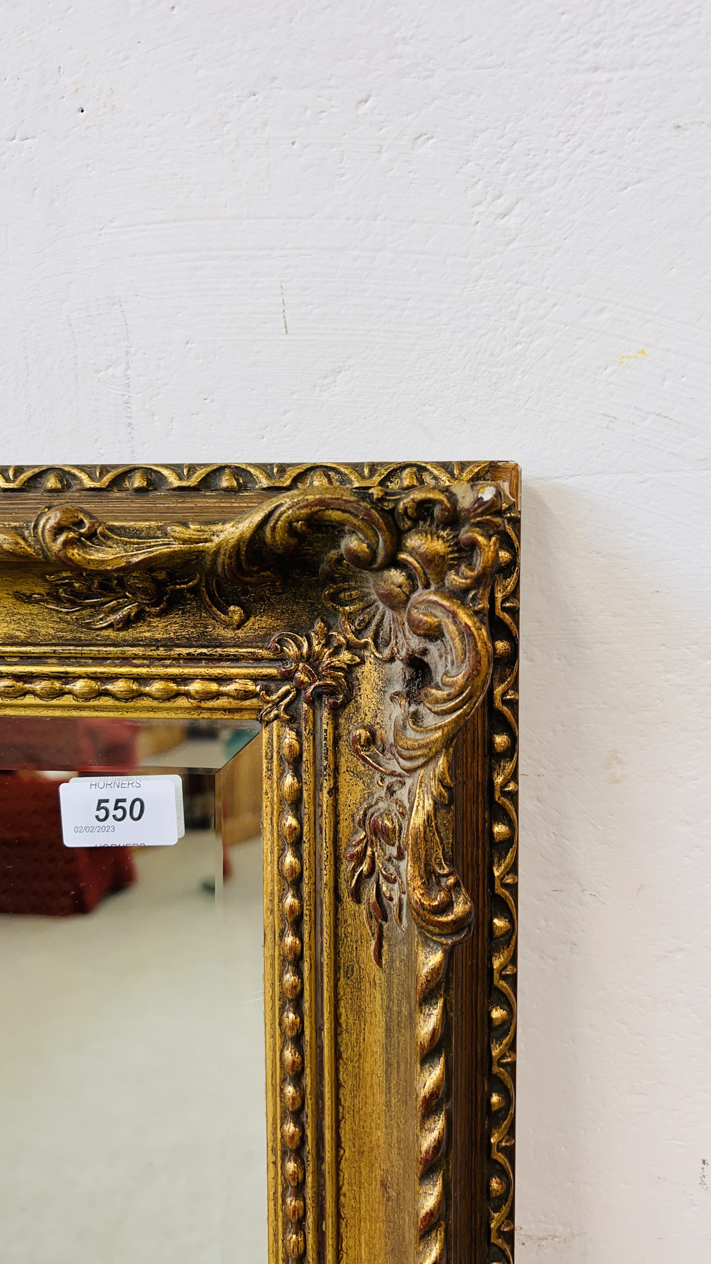 A LARGE HEAVILY DETAILED GILT FRAMED WALL MIRROR WITH BEVELLED GLASS. - Image 2 of 5