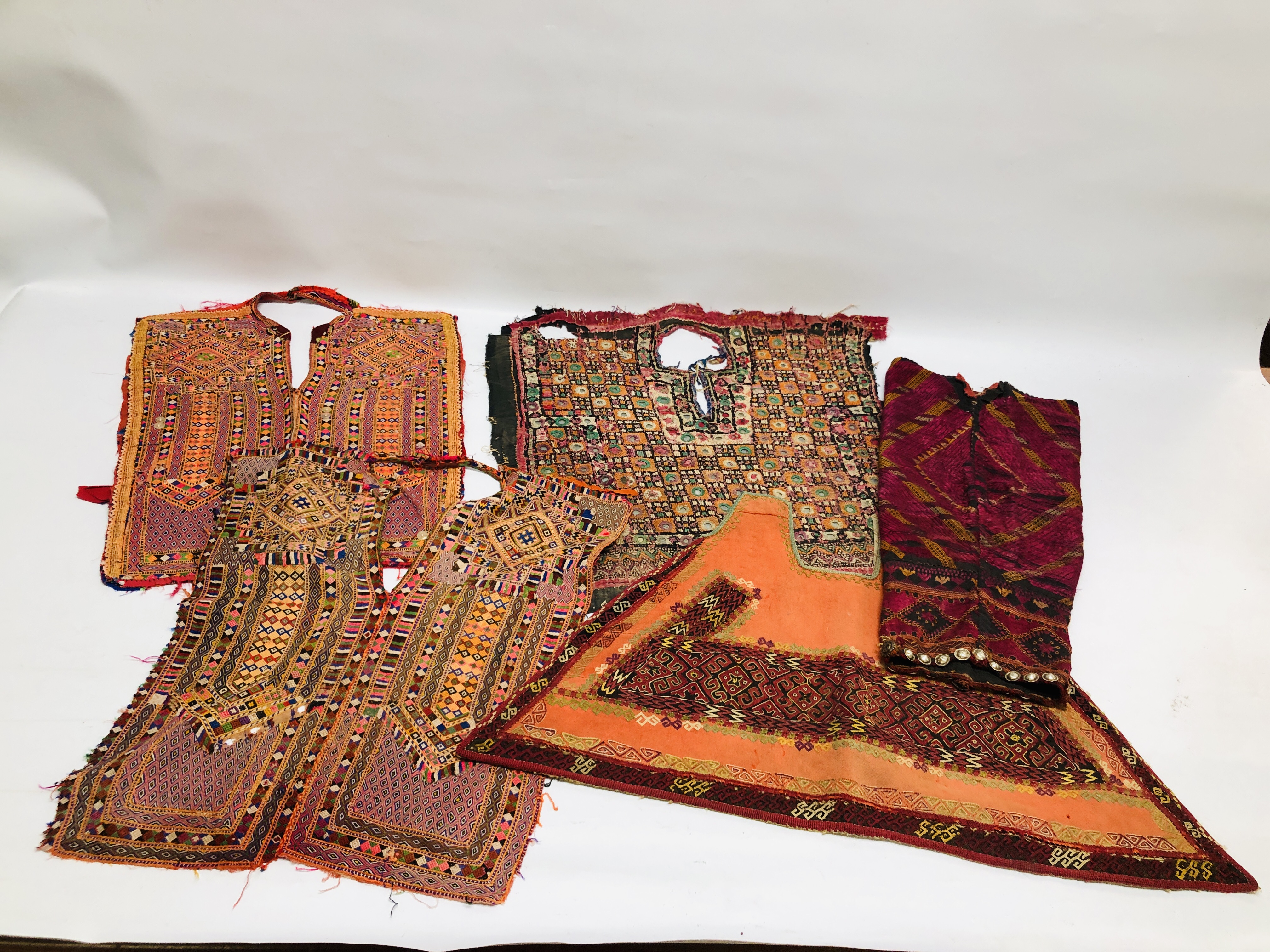 A GROUP OF ETHNIC AND TRIBAL GARMENTS TO INCLUDE DRESS YOLKS TO INCLUDE ELABORATELY HAND MADE