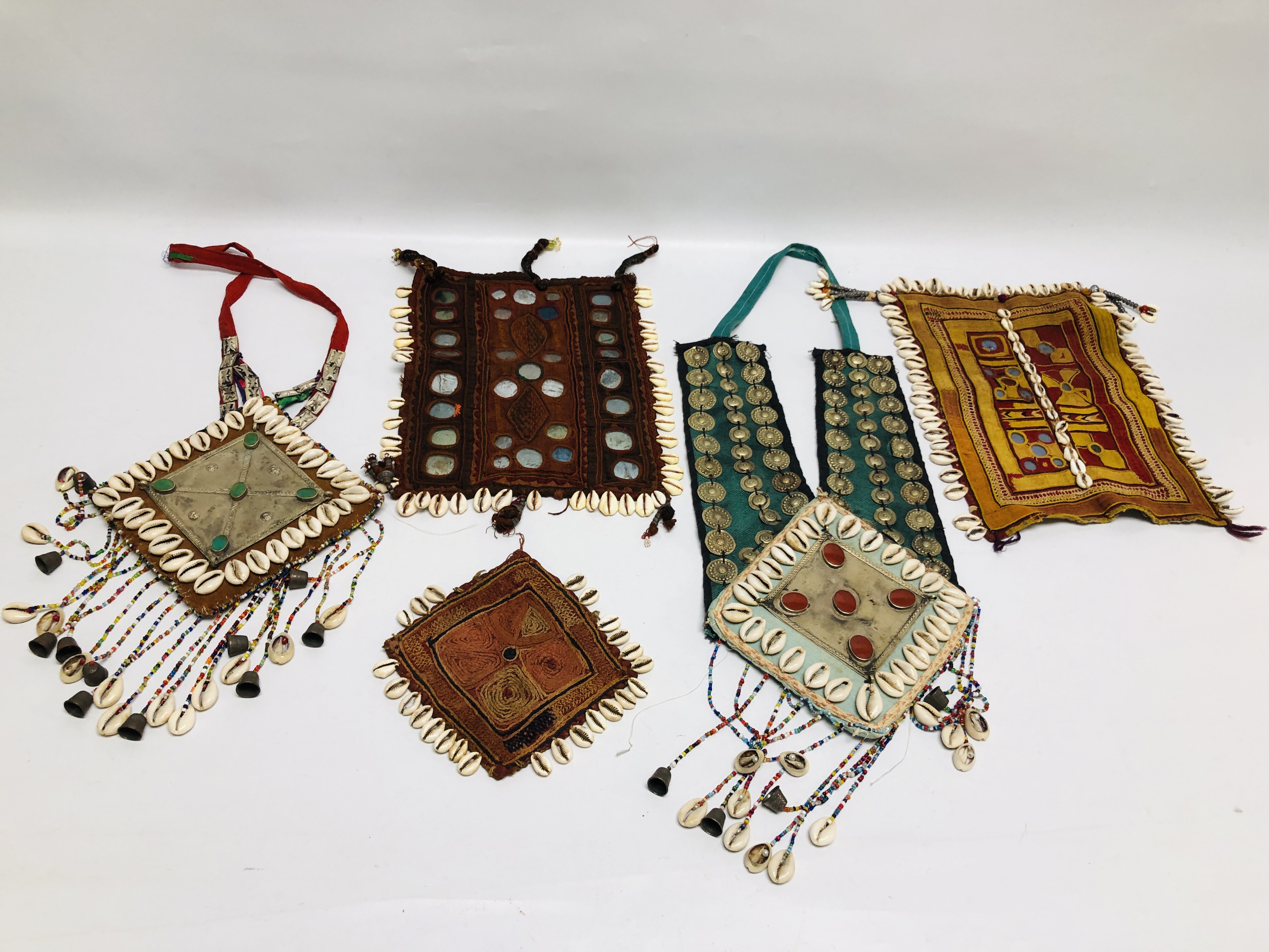 A GROUP OF FIVE VARIOUS AFGHAN TEXTILE PIECES APPLIED WITH COWRIE SHELLS AND OTHER DECORATION