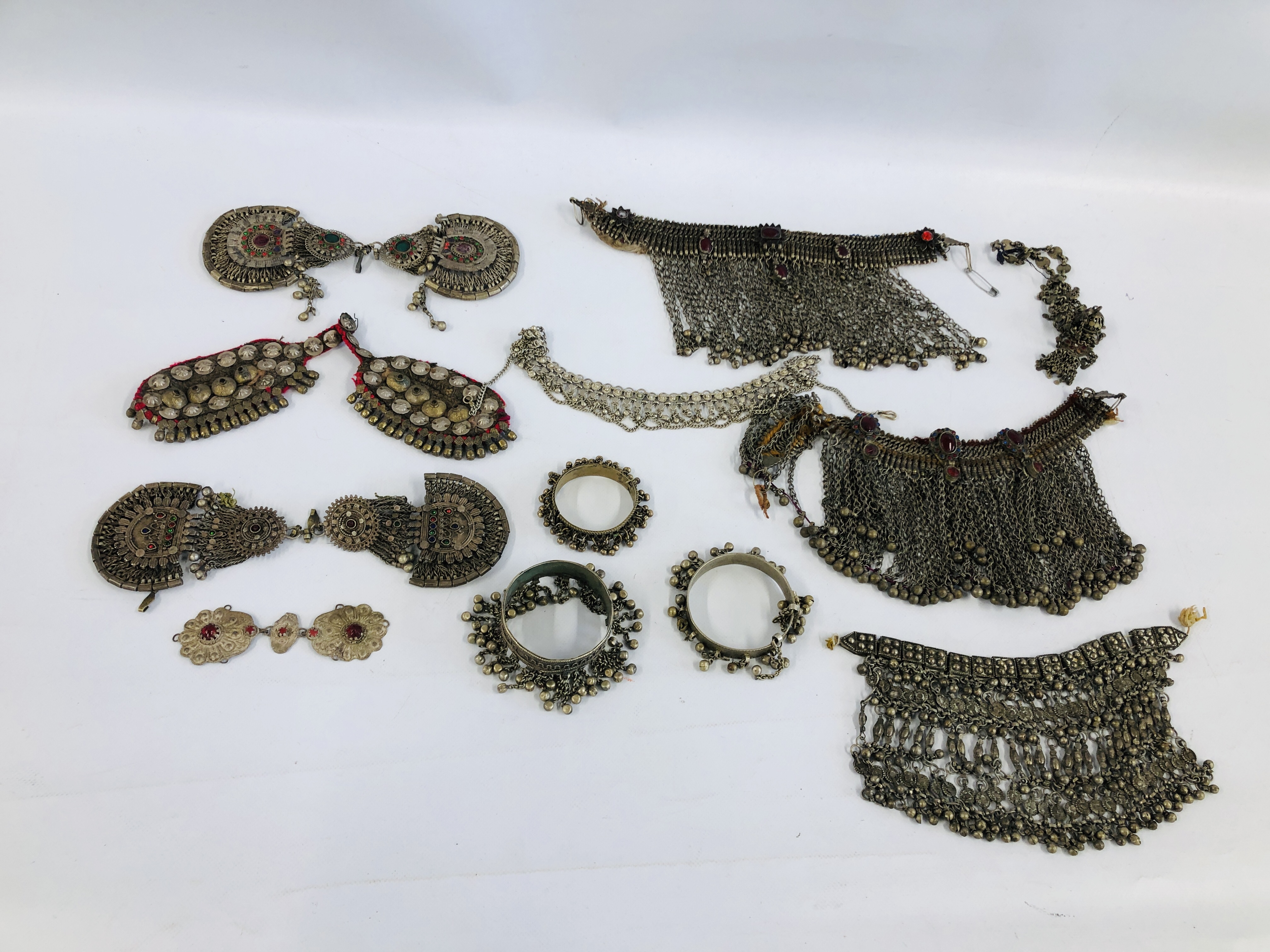 A GROUP OF EASTERN STYLE WHITE METAL JEWELED CLOTHING / GARMENT ACCESSORIES AND ANKLETS ETC.