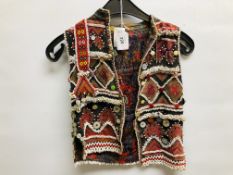 AN ELABORATE PERSIAN STYLE EMBROIDERED CHILD'S WAIST COAT DECORATED WITH INTRICATE BEADWORK AND
