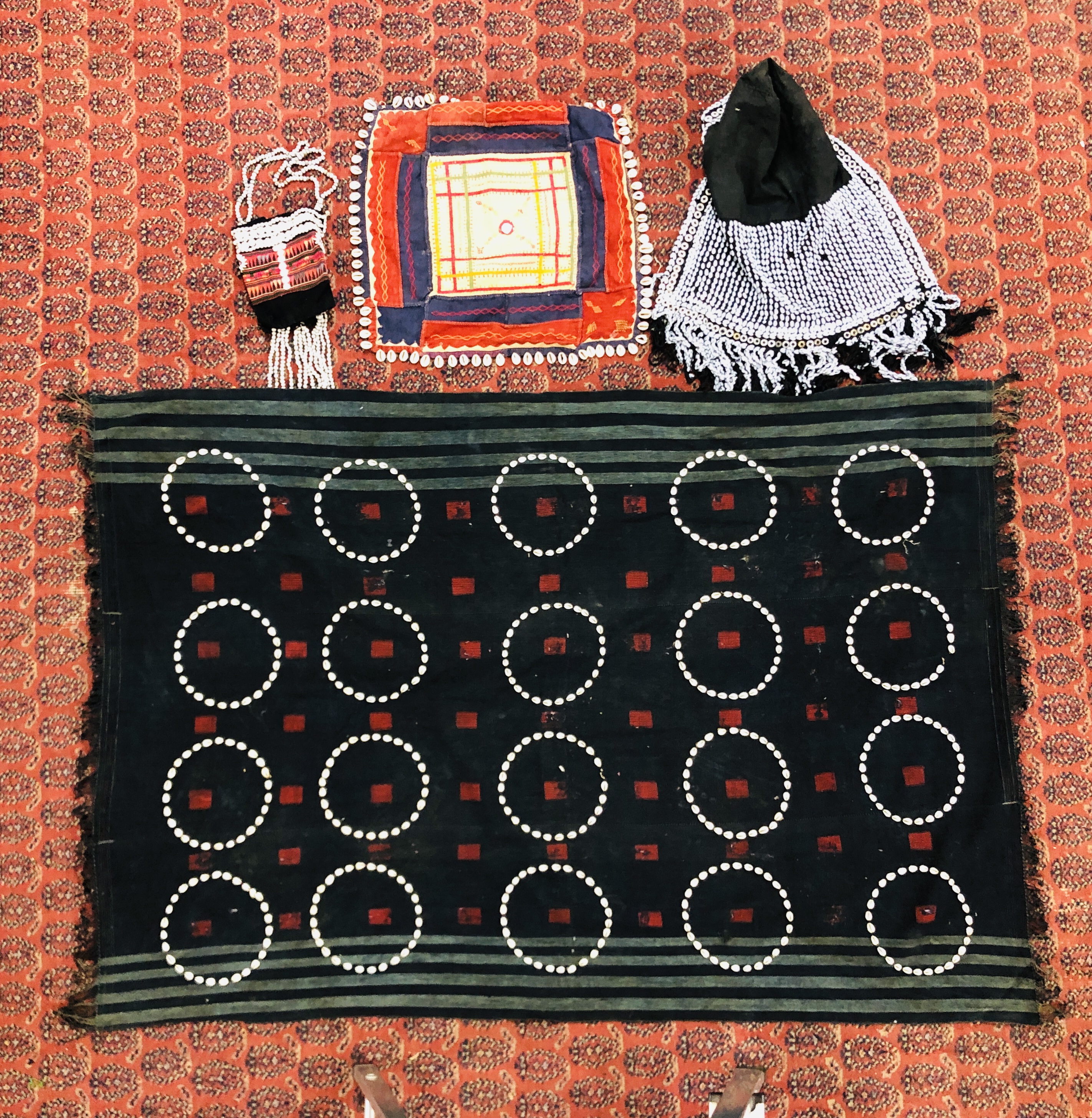 A GROUP OF ETHNIC TRIBAL TEXTILES TO INCLUDE A CLOTH / COVER DECORATED WITH "COWRIE" SHELL APPLIED