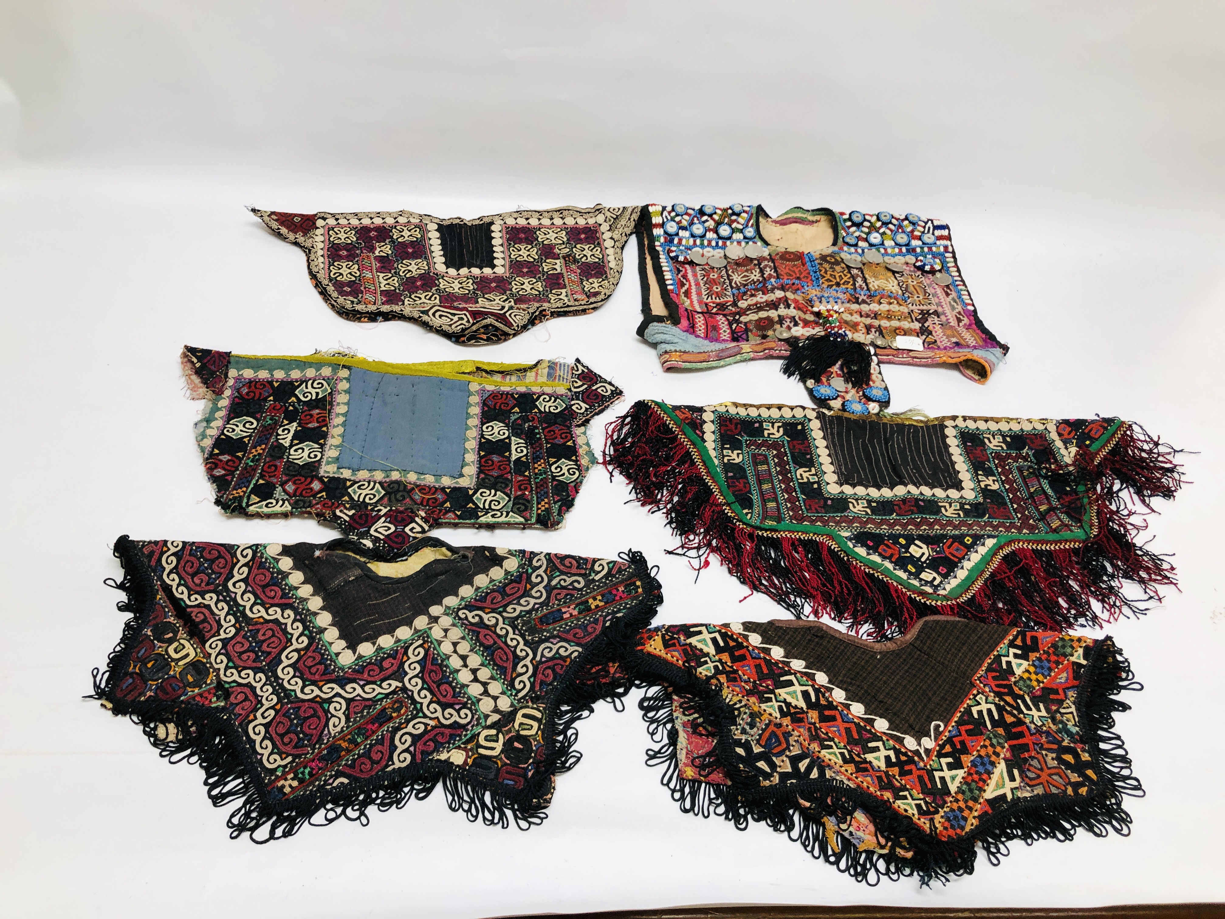 A GROUP OF 5 ASIAN TRIBAL TEXTILE GARMENTS TO INCLUDE SUZANI EXAMPLES.