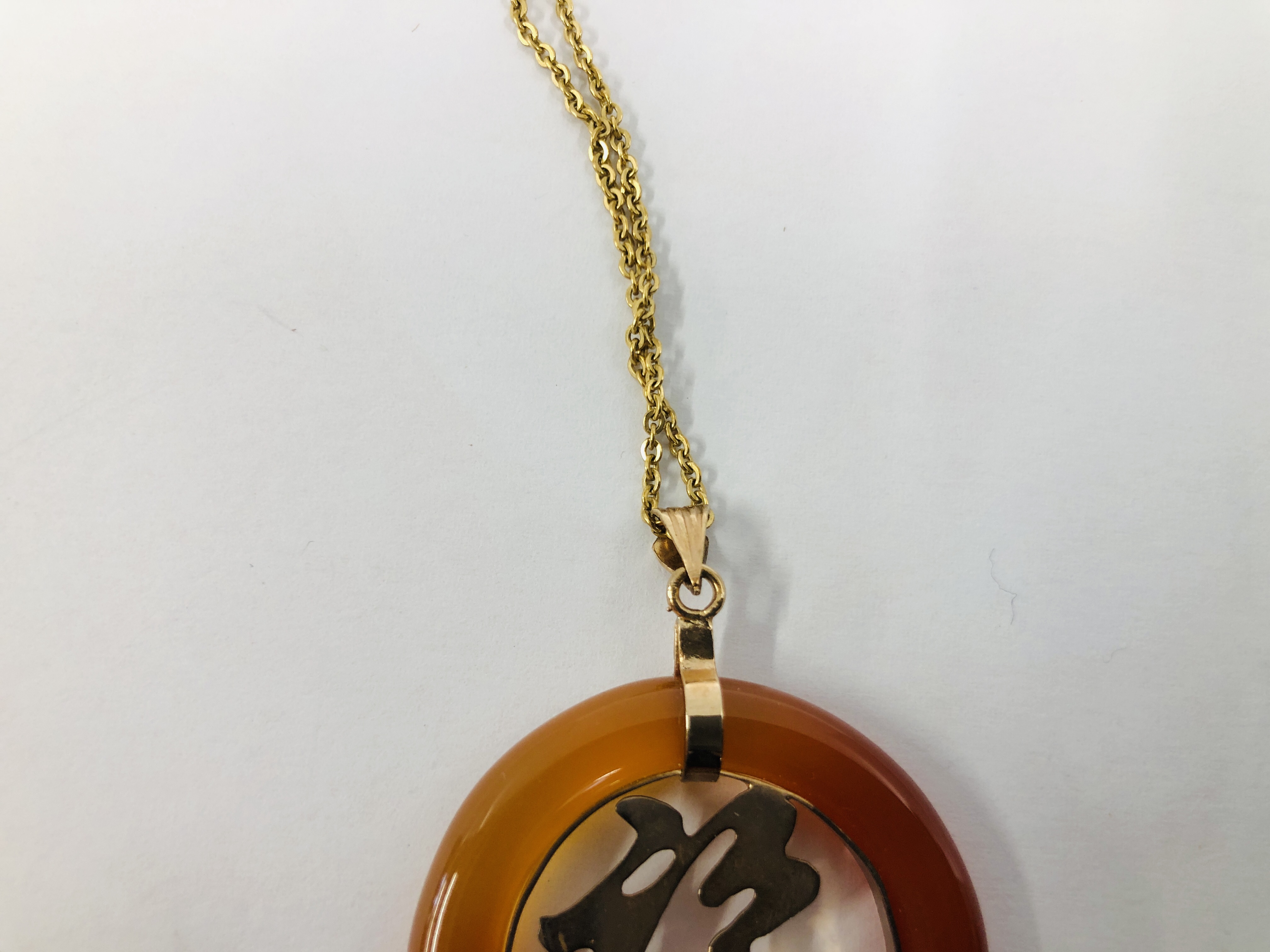 AN ORIENTAL CIRCULAR PENDANT WITH HARDSTONE SURROUND ON A FINE CHAIN MARKED 12K. - Image 6 of 14