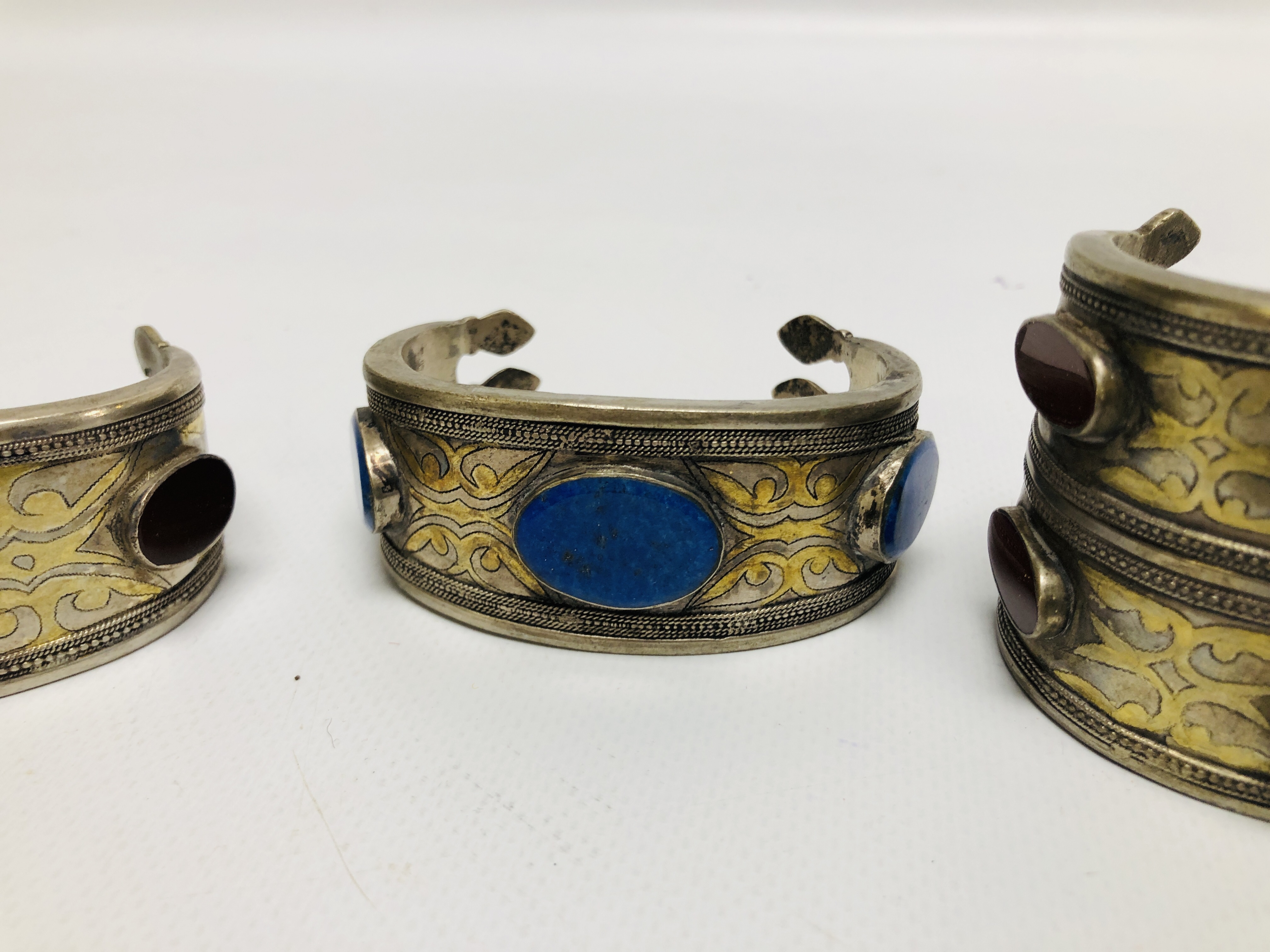 A GROUP OF 4 EASTERN STYLE WHITE METAL CUFF BRACELETS, INSET WITH OVAL STONES. - Image 4 of 8