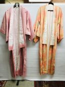 TWO MODERN JAPANESE SILK KIMONOS ONE ON A PASTEL PEACH FIELD HAVING A WOVEN PEACOCK FEATHER DESIGN