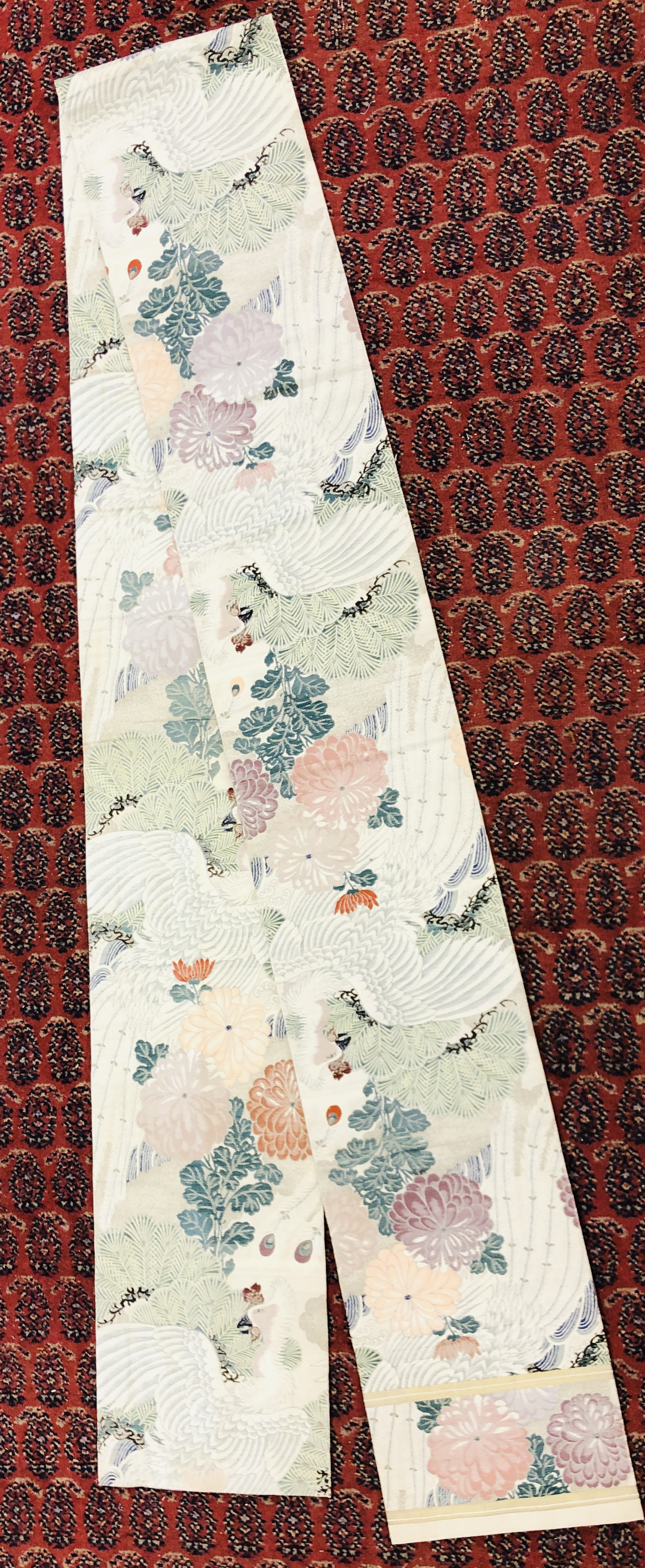 A CHINESE SILK "OBI" ON AN IVORY FIELD DECORATED WITH BIRDS AND FLOWERS.