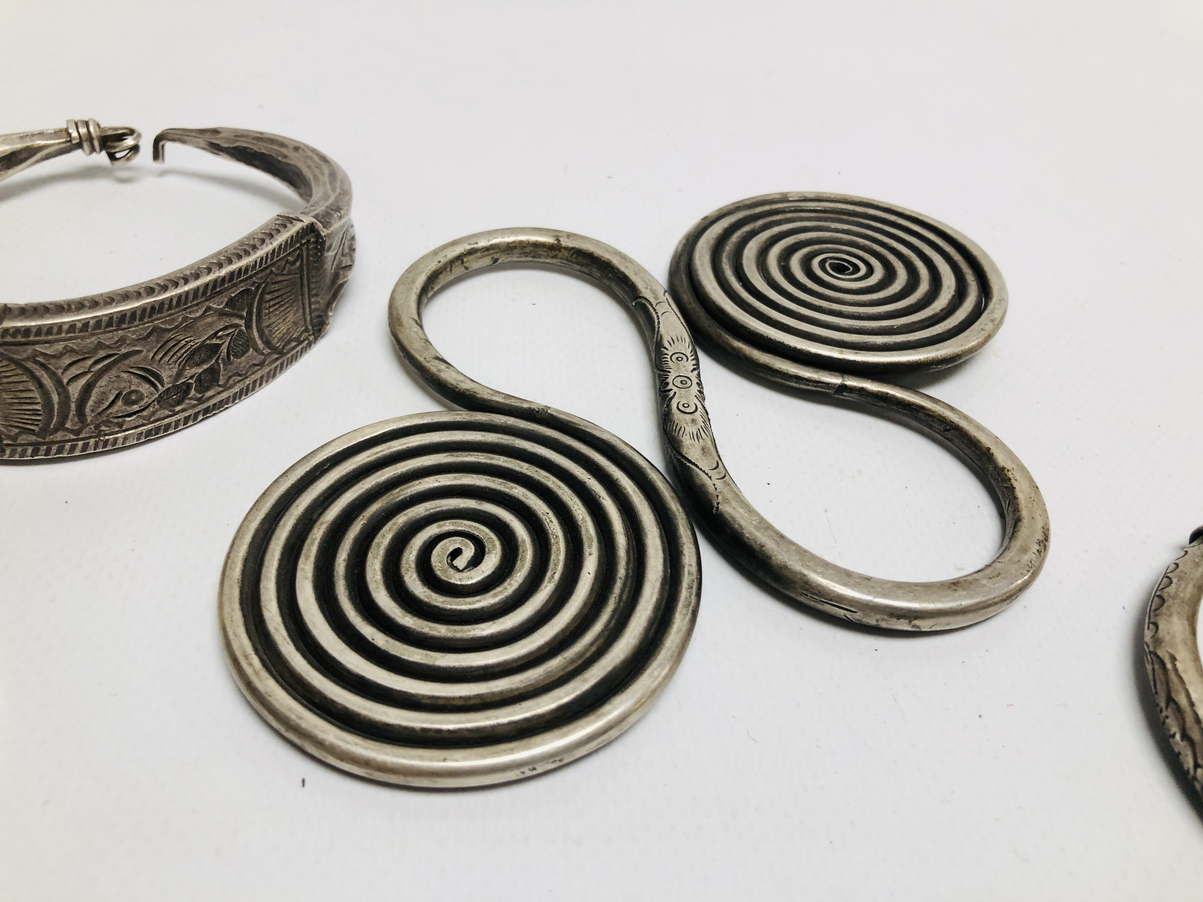 THREE EASTERN TRIBAL STYLE WHITE METAL CUFF BRACELETS OF HAMMERED DESIGN ALONG WITH A FURTHER WHITE - Image 4 of 5