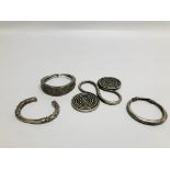 THREE EASTERN TRIBAL STYLE WHITE METAL CUFF BRACELETS OF HAMMERED DESIGN ALONG WITH A FURTHER WHITE