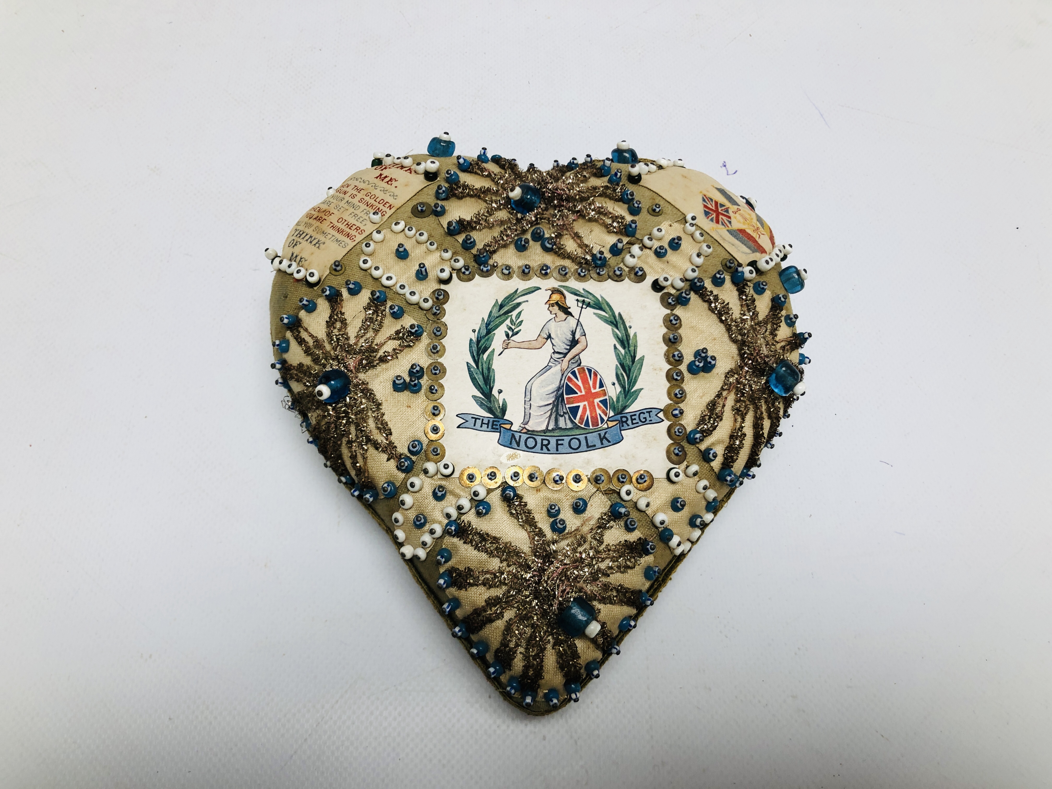 A VINTAGE WWI HEART SHAPED SWEETHEART PIN CUSHION, BEADED DETAIL "NORFOLK REG'T".