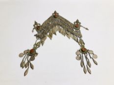 AN ELABORATE EASTERN TRIBAL STYLE WHITE METAL HEAD GARMENT INSET WITH COLOURED STONES.