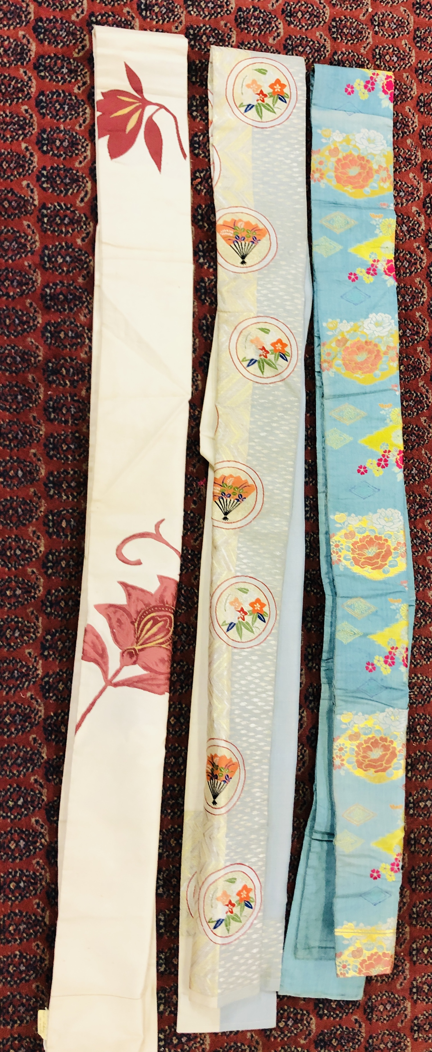 A GROUP OF THREE ORIENTAL SILK STYLE EMBROIDERED "OBI".