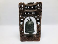 AN ORIENTAL BELL CAST WITH DEER IN A CARVED HARDWOOD FRAME HEIGHT 41CM.