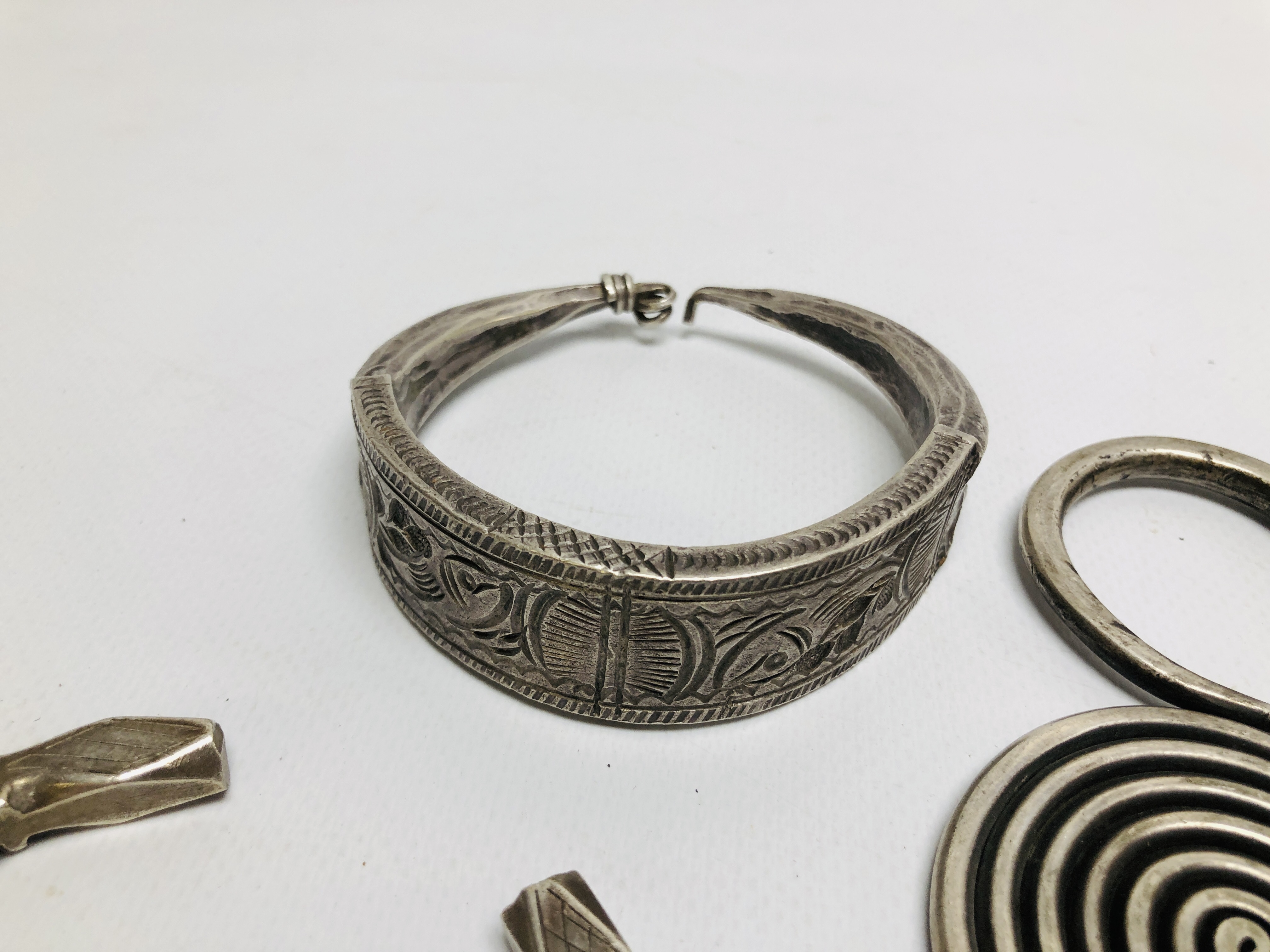 THREE EASTERN TRIBAL STYLE WHITE METAL CUFF BRACELETS OF HAMMERED DESIGN ALONG WITH A FURTHER WHITE - Image 3 of 5