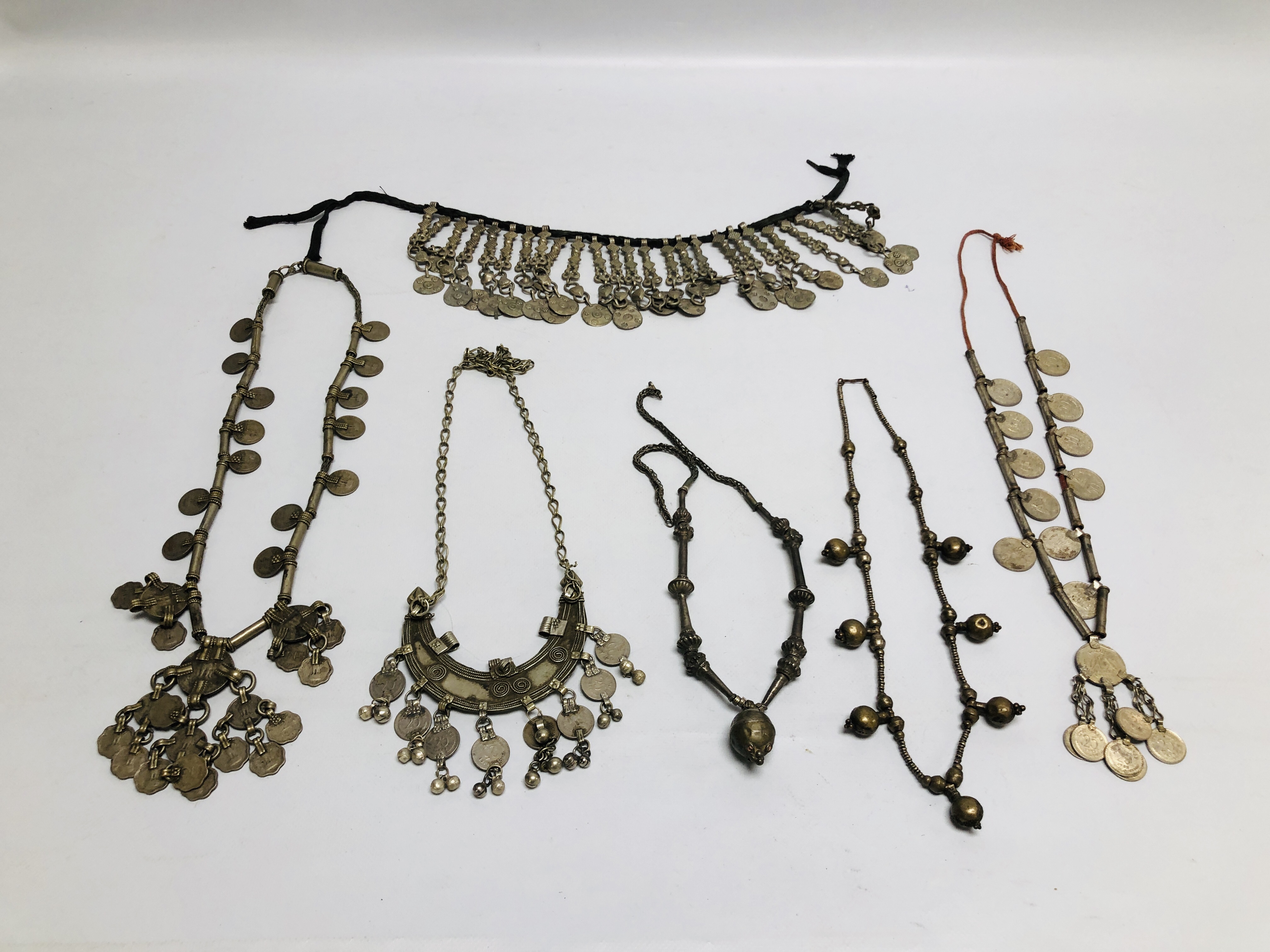 A GROUP OF 6 ASSORTED EASTERN TRIBAL STYLE NECKLACES TO INCLUDE COIN SET EXAMPLES.