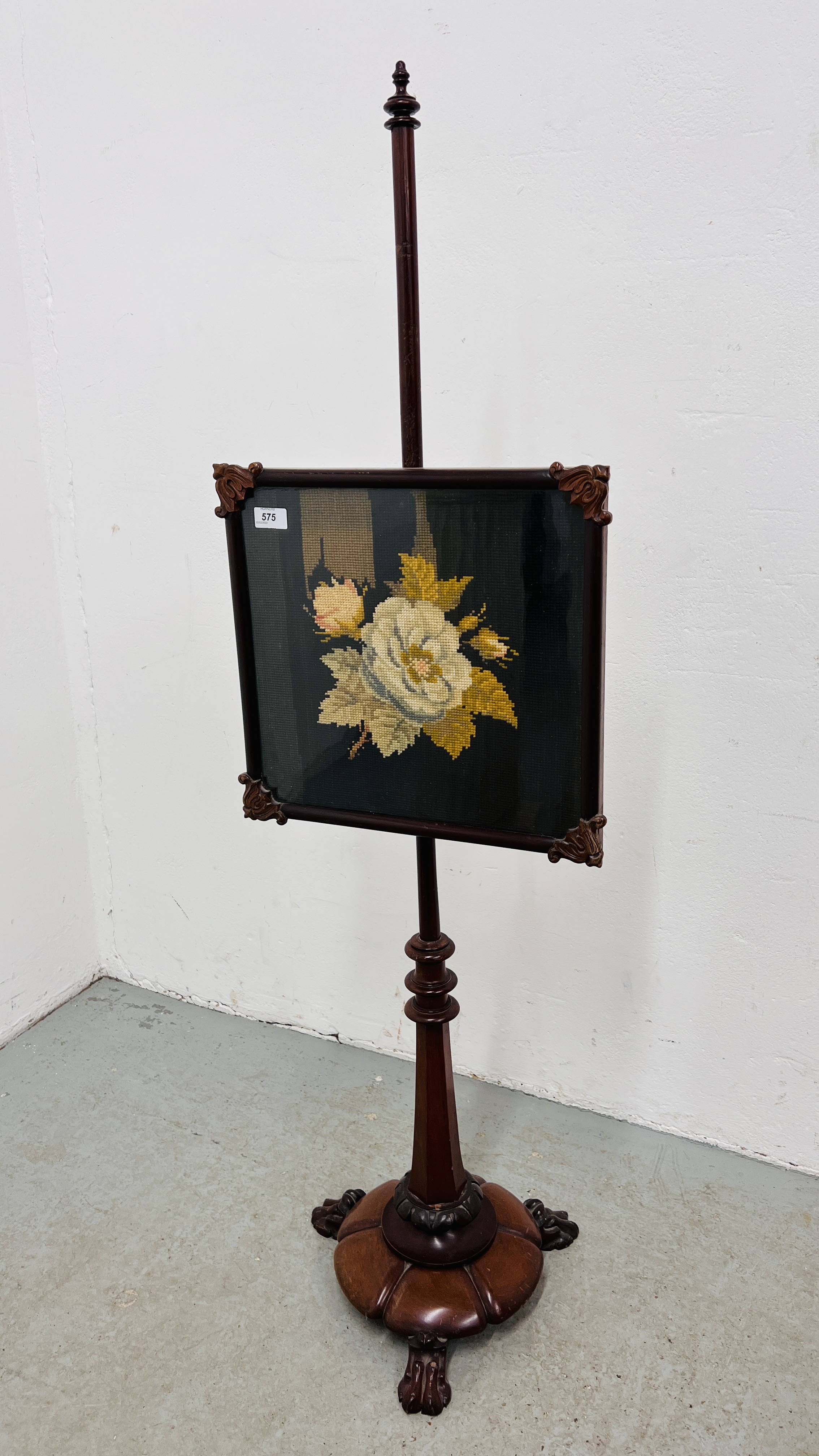 A VICTORIAN MAHOGANY POLE SCREEN, THE PANEL DECORATED WITH FLORAL TAPESTRY, THE BASE WITH CLAW FOOT.