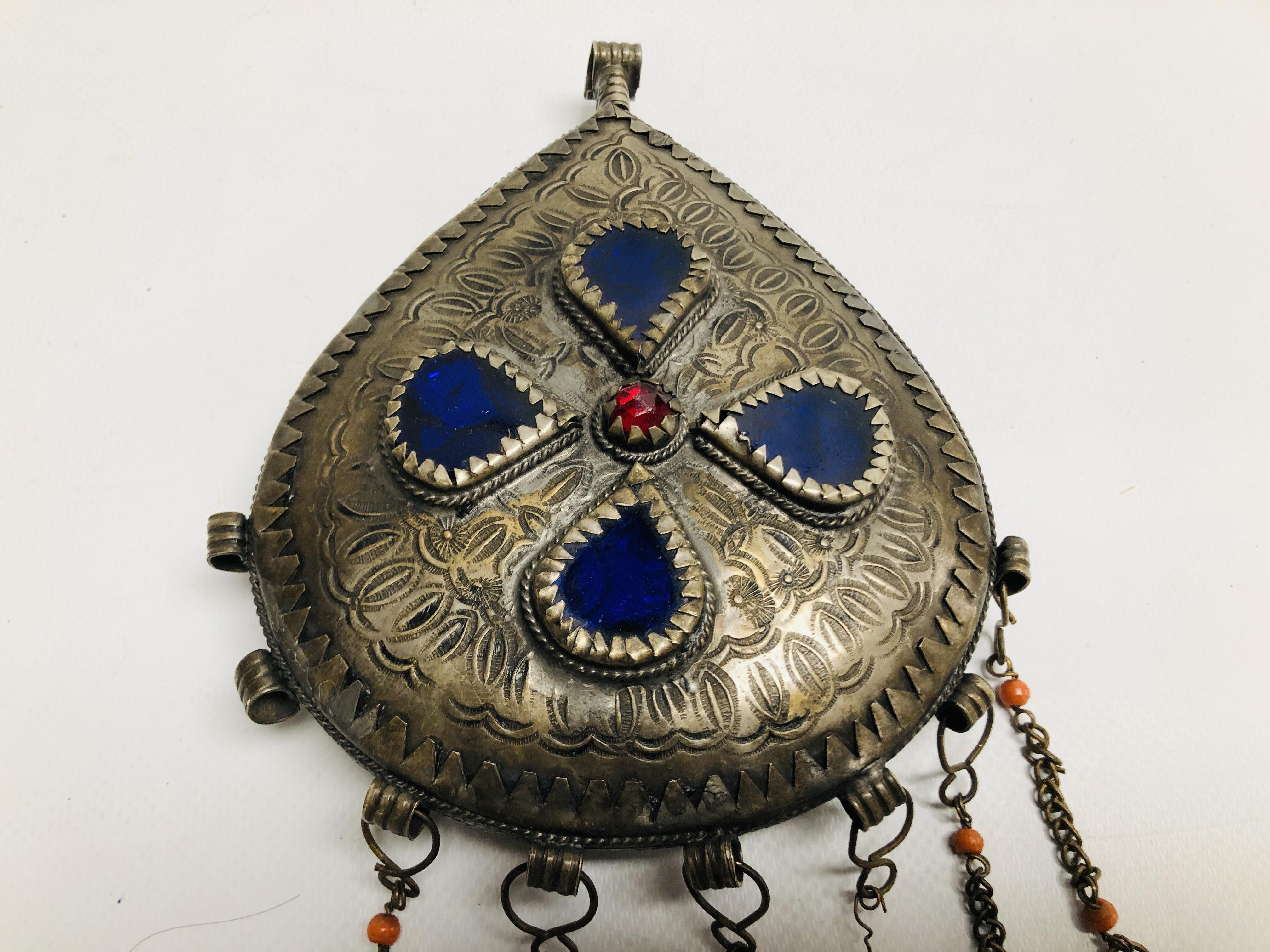AN ELABORATE LARGE EASTERN TRIBAL STYLE PENDANT, HAMMERED DESIGN INSET WITH COLOURED GLASS. - Image 3 of 6