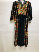 AN ASIAN INSPIRED BLACK VELVET DRESS WITH COLOURFUL ELABORATE EMBROIDERED FLOWERS