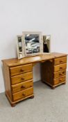 A WAXED PINE EIGHT DRAWER KNEE HOLE DRESSING TABLE AND TRIPLE VANITY MIRROR.