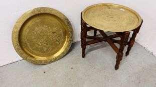 2 LARGE VINTAGE BRASS CIRCULAR TRAYS ON A WOODEN STAND.