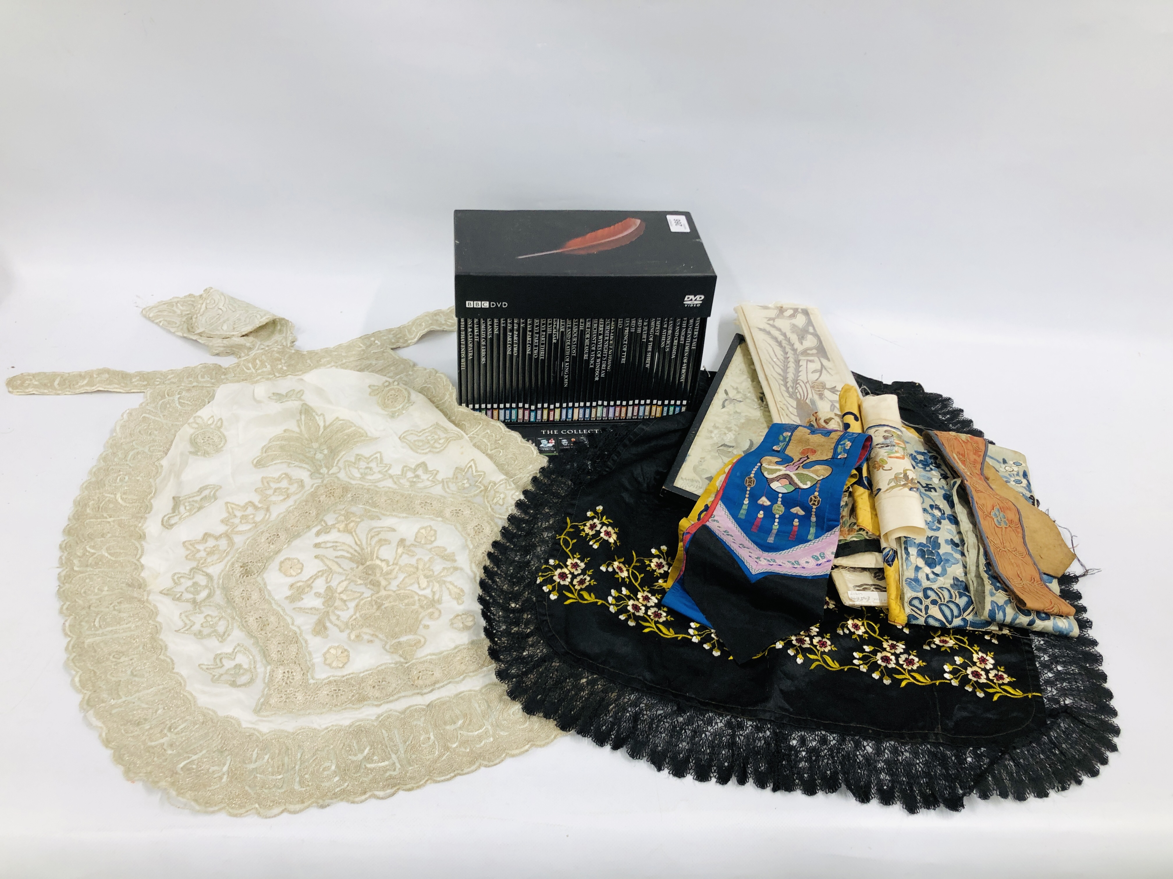 AN ELABORATE SILK AND LACE PANEL IN AN APRON STYLE WOVEN WITH AN INTRICATE FLORAL PATTERN ALONG