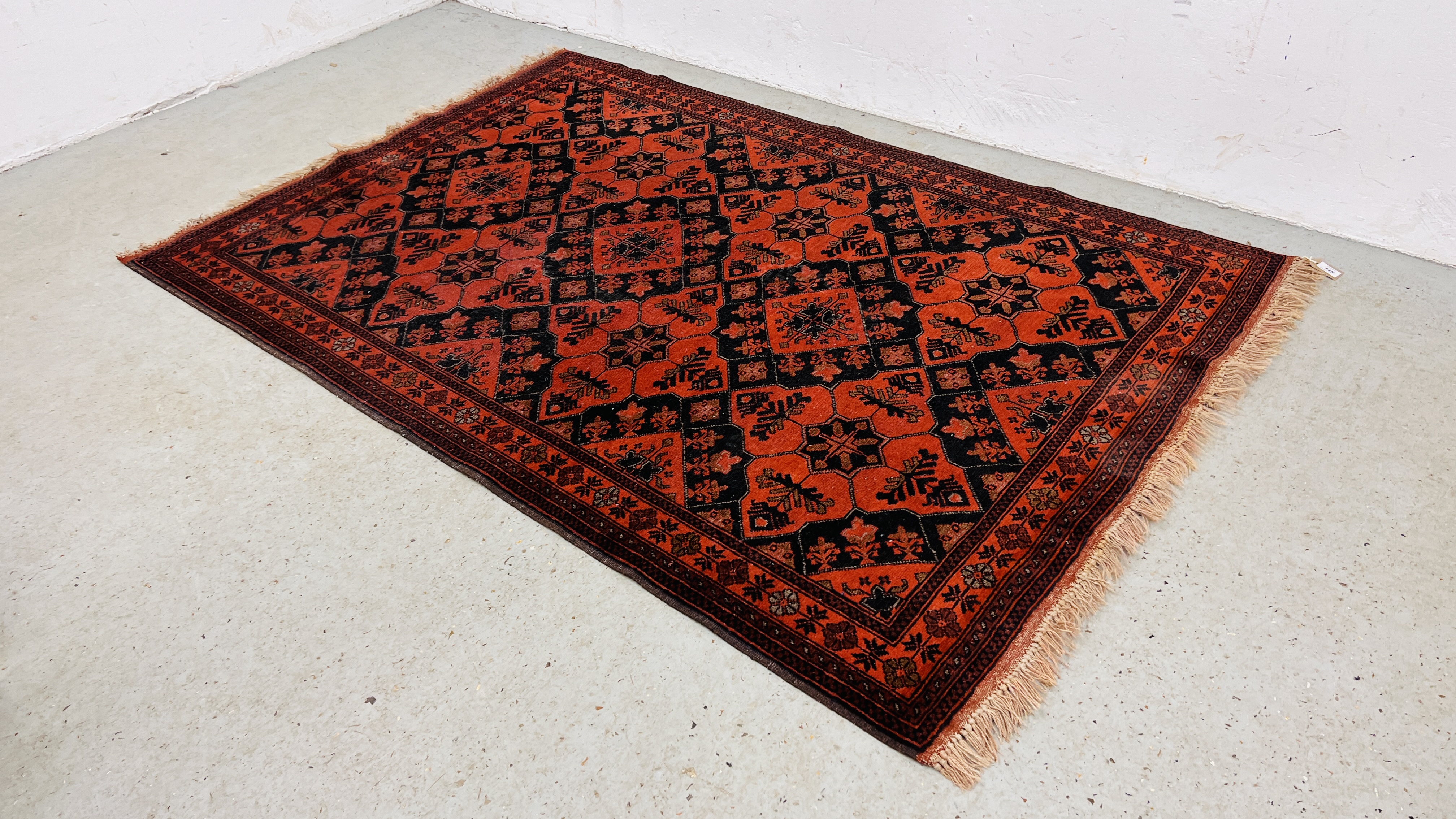 A RED PATTERNED EASTERN RUG.