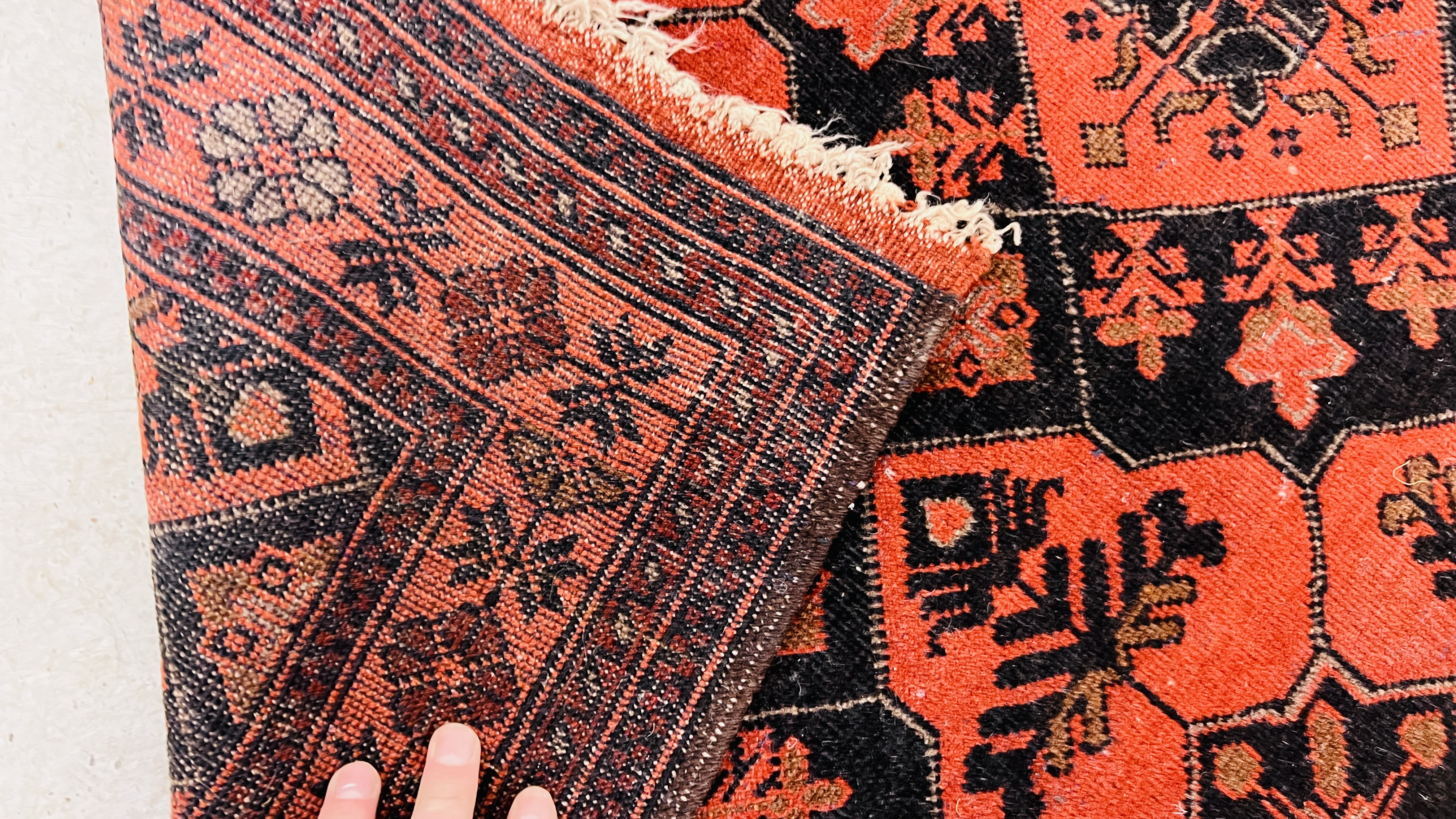 A RED PATTERNED EASTERN RUG. - Image 6 of 6