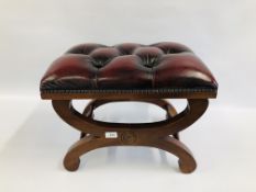 AN OXBLOOD LEATHER BUTTON BACK FOOT STOOL ON STRETCHER BASE.