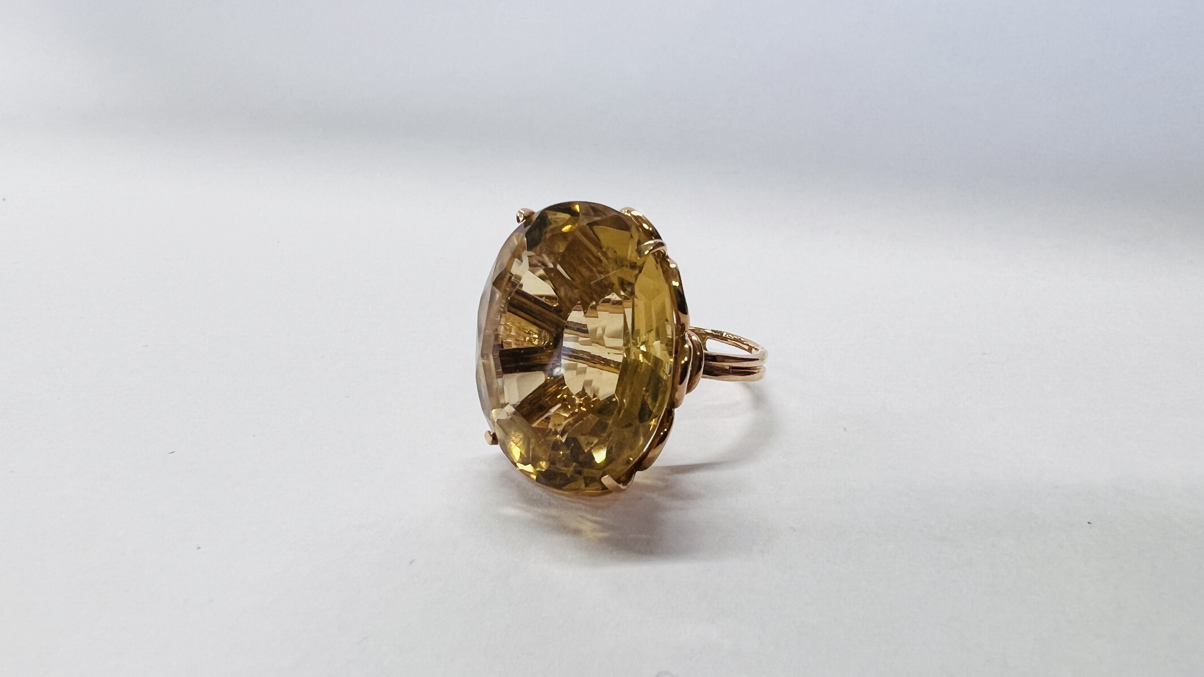 AN OVERSIZE AMBER COLOURED STONE SET DRESS RING, THE SHANK MARKED 750, SIZE M/N.