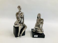 TWO MODERN ART NUDE STUDIES IN A SILVER METALLIC FINISH.