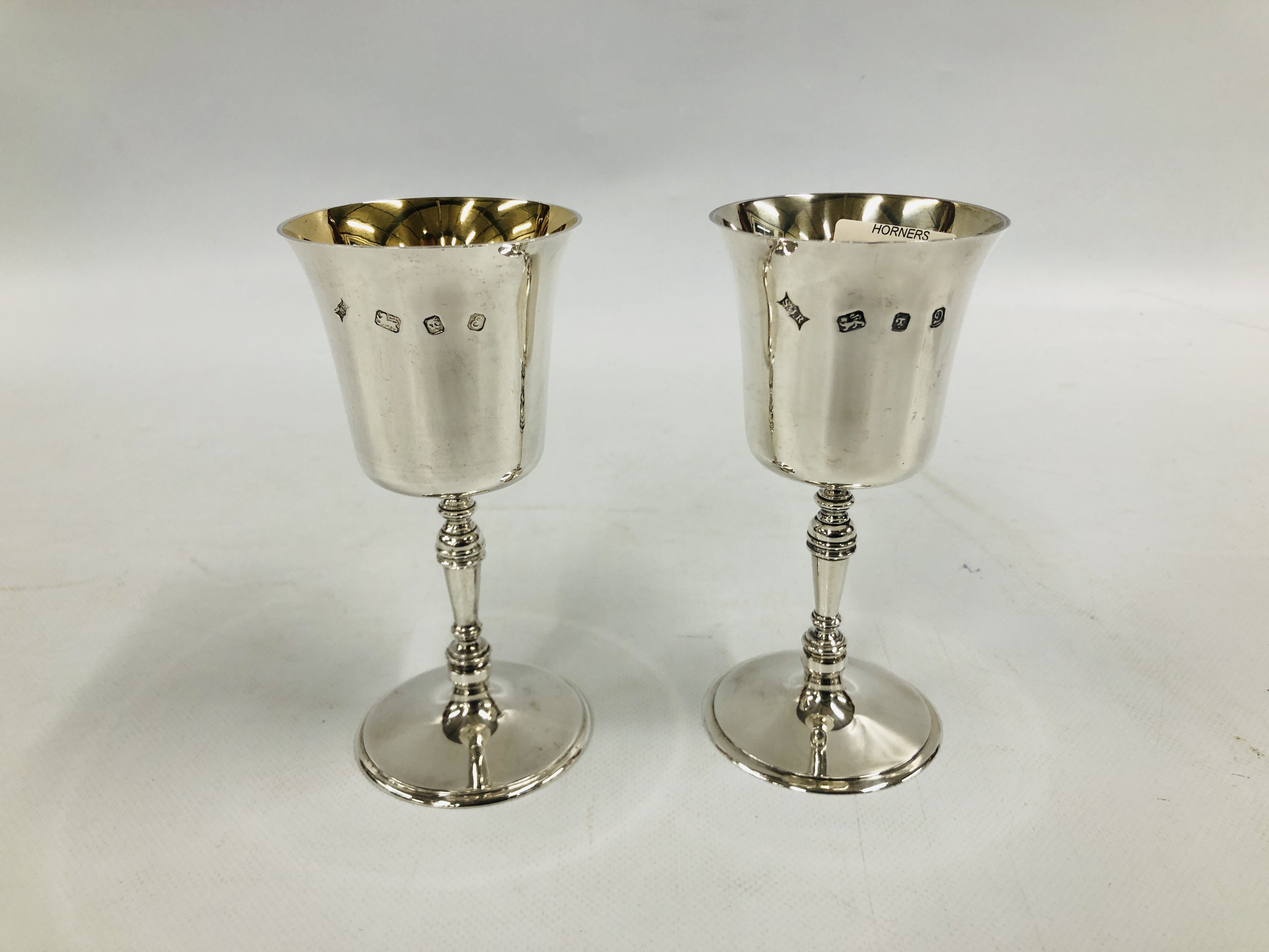 A PAIR OF SILVER AND GILT GOBLETS, LONDON ASSAY BEARING MAKERS INITIALS S.J.R. - H 16CM.