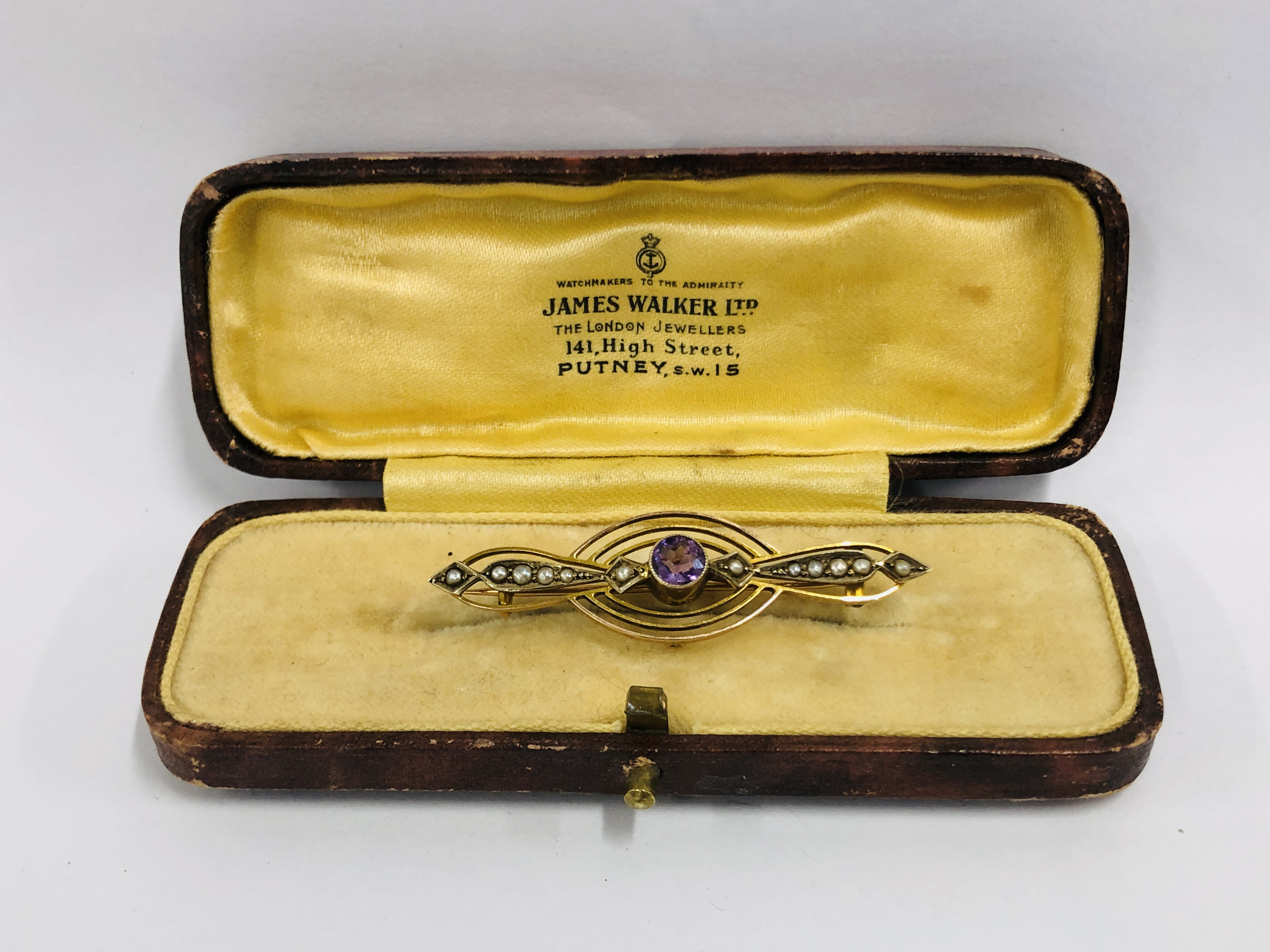 A VINTAGE 9CT BROOCH / PENDANT SET WITH CENTRAL AMETHYST AND SEED PEARLS IN A VINTAGE BOX MARKED