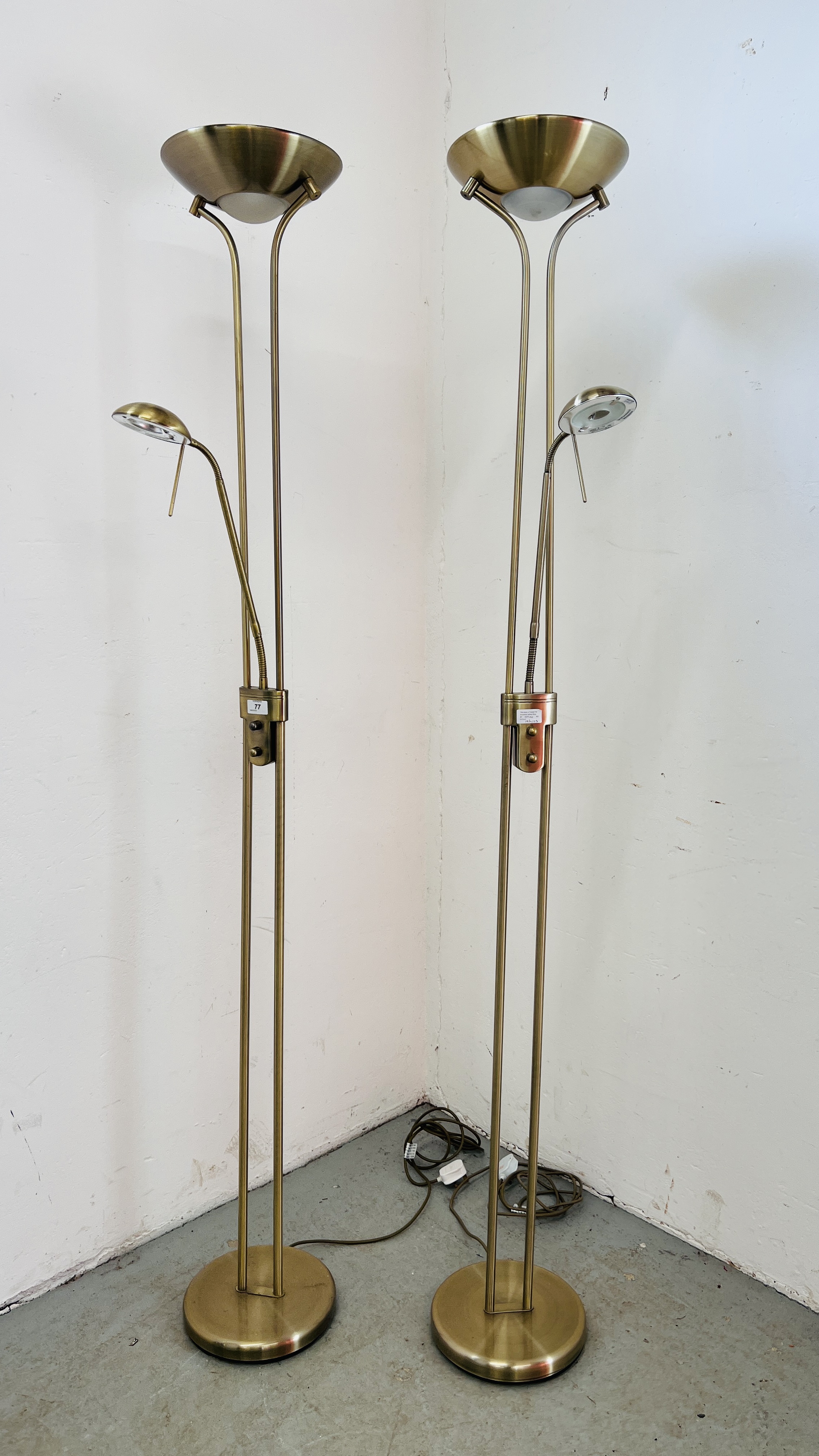 A PAIR OF MODERN BRASS EFFECT UPLIGHTERS WITH READING LIGHTS - SOLD AS SEEN.