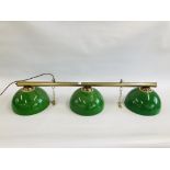 A VINTAGE STYLE CEILING SUSPENDED THREE BULB LIGHT BAR ON BRASS EFFECT TUBE AND GREEN SHADES - SOLD