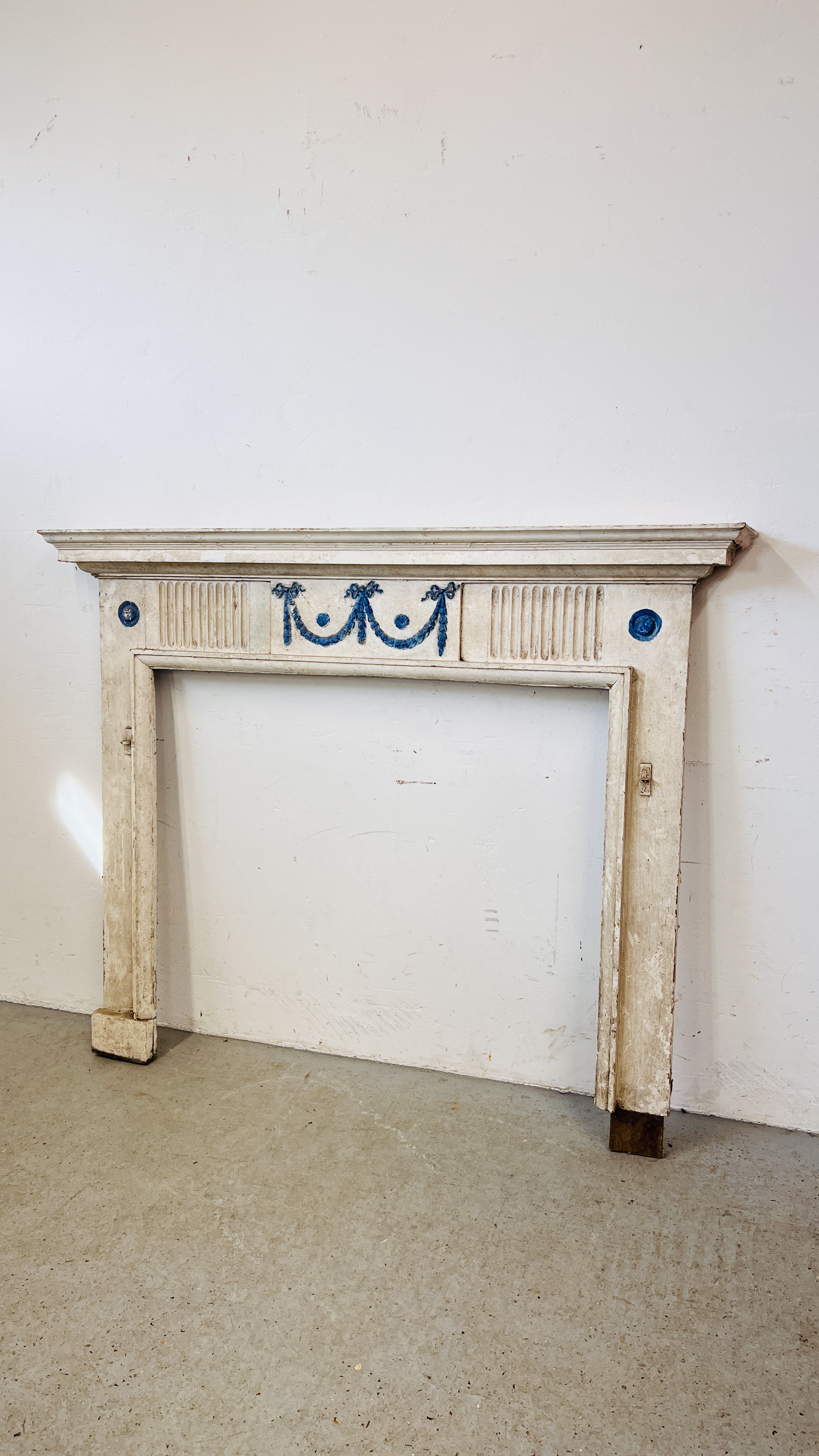 A WHITE PAINTED ANTIQUE FIRE SURROUND - OPENING WIDTH 105M. HEIGHT 93CM.