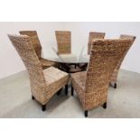 A DESIGNER DINING SET COMPRISING GLASS TOP CIRCULAR TABLE DIAMETER 140CM AND SET OF SIX BANANA LEAF