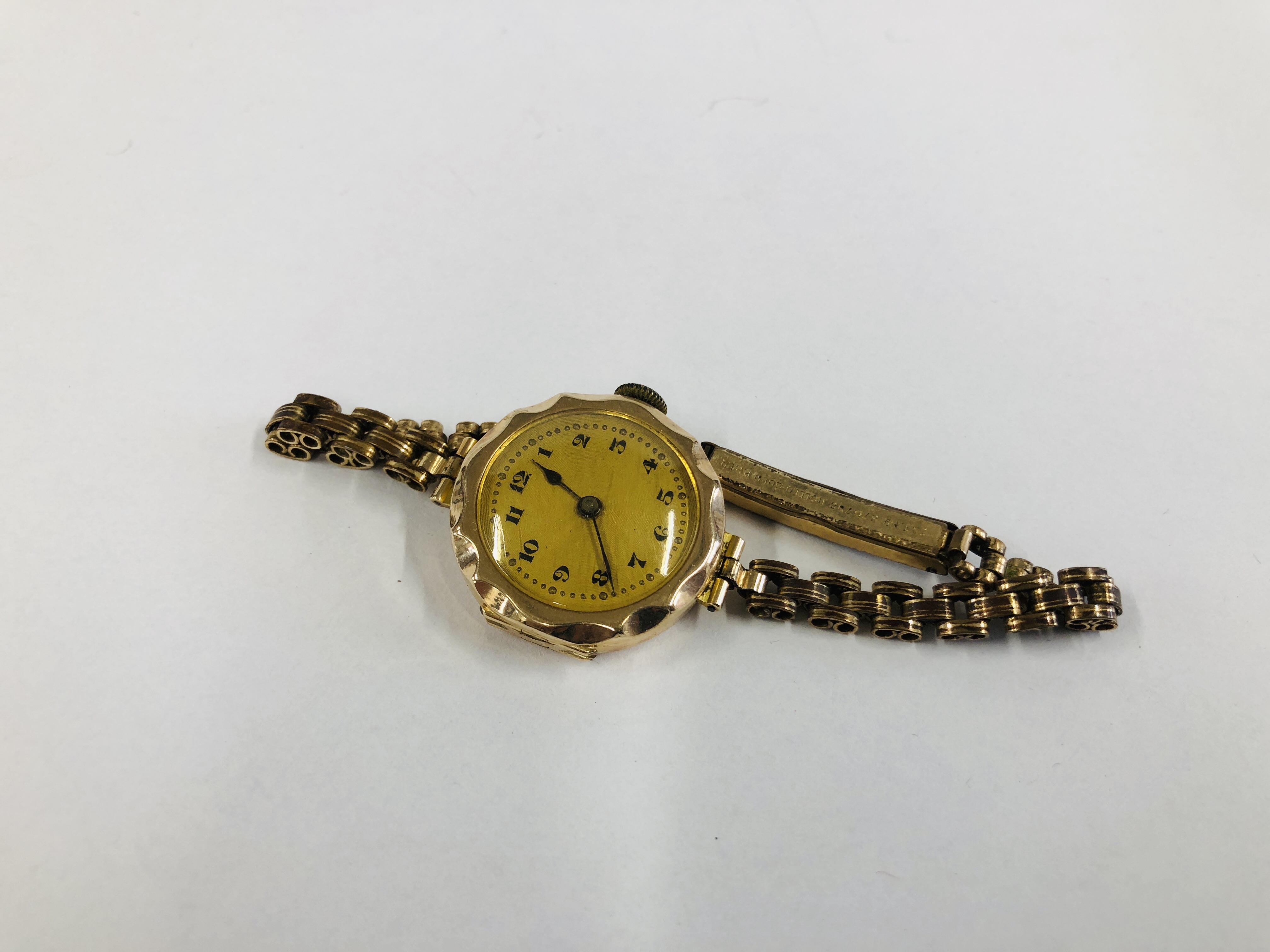 A LADIES 9CT GOLD WRIST WATCH ON A PLATED STRAP