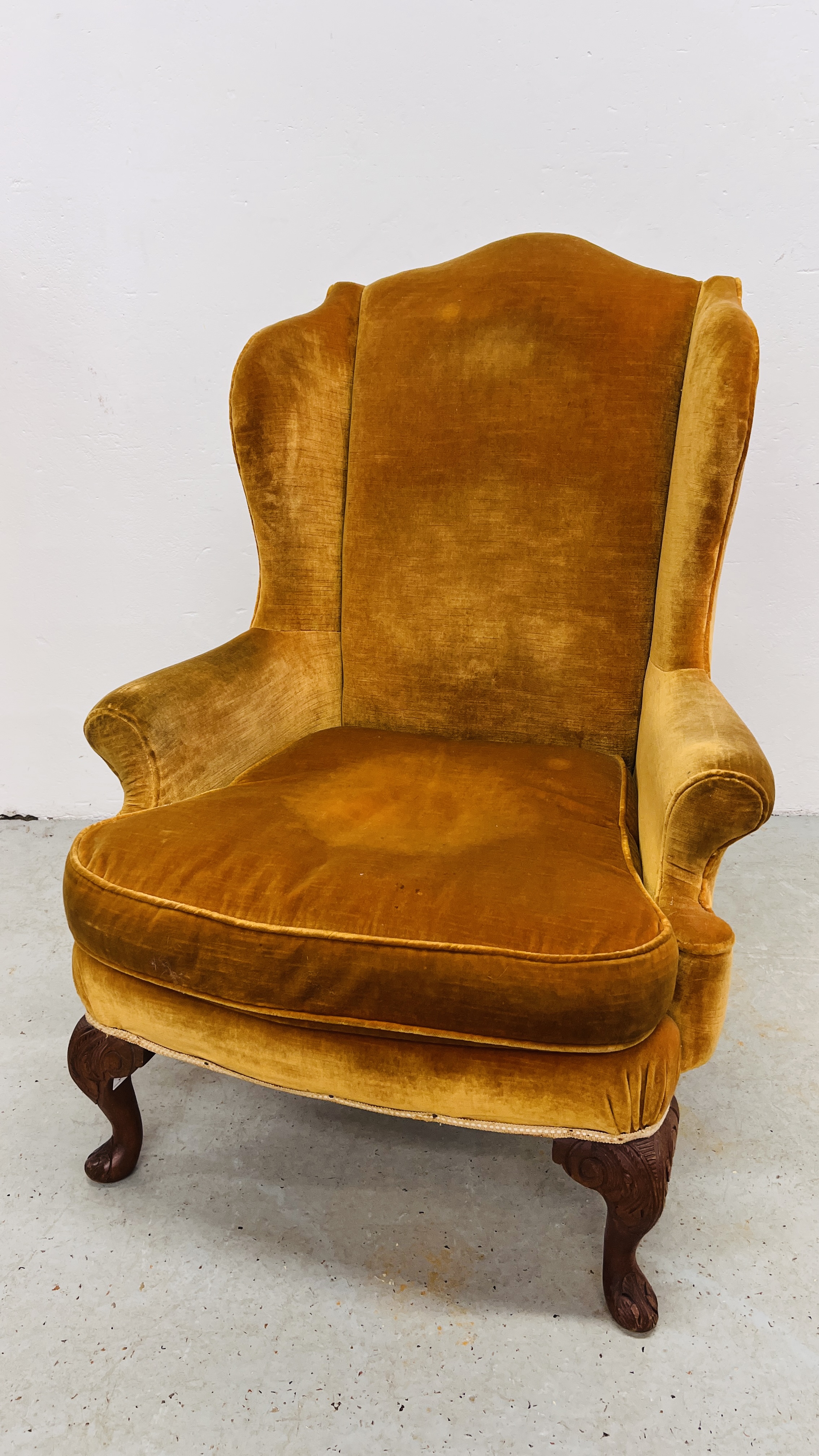 A MAHOGANY WINGED ARMCHAIR (COVER STAINED)