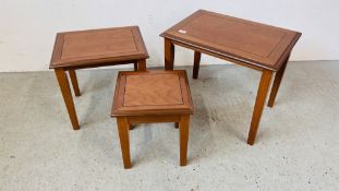 A NEST OF THREE GRADUATED CHERRYWOOD FINISH OCCASIONAL TABLES.