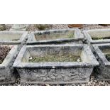 A PAIR OF HEAVY RECTANGULAR STONEWORK PLANTING TROUGHS WITH RELIEF CHERUB DECORATION. W 88CM.