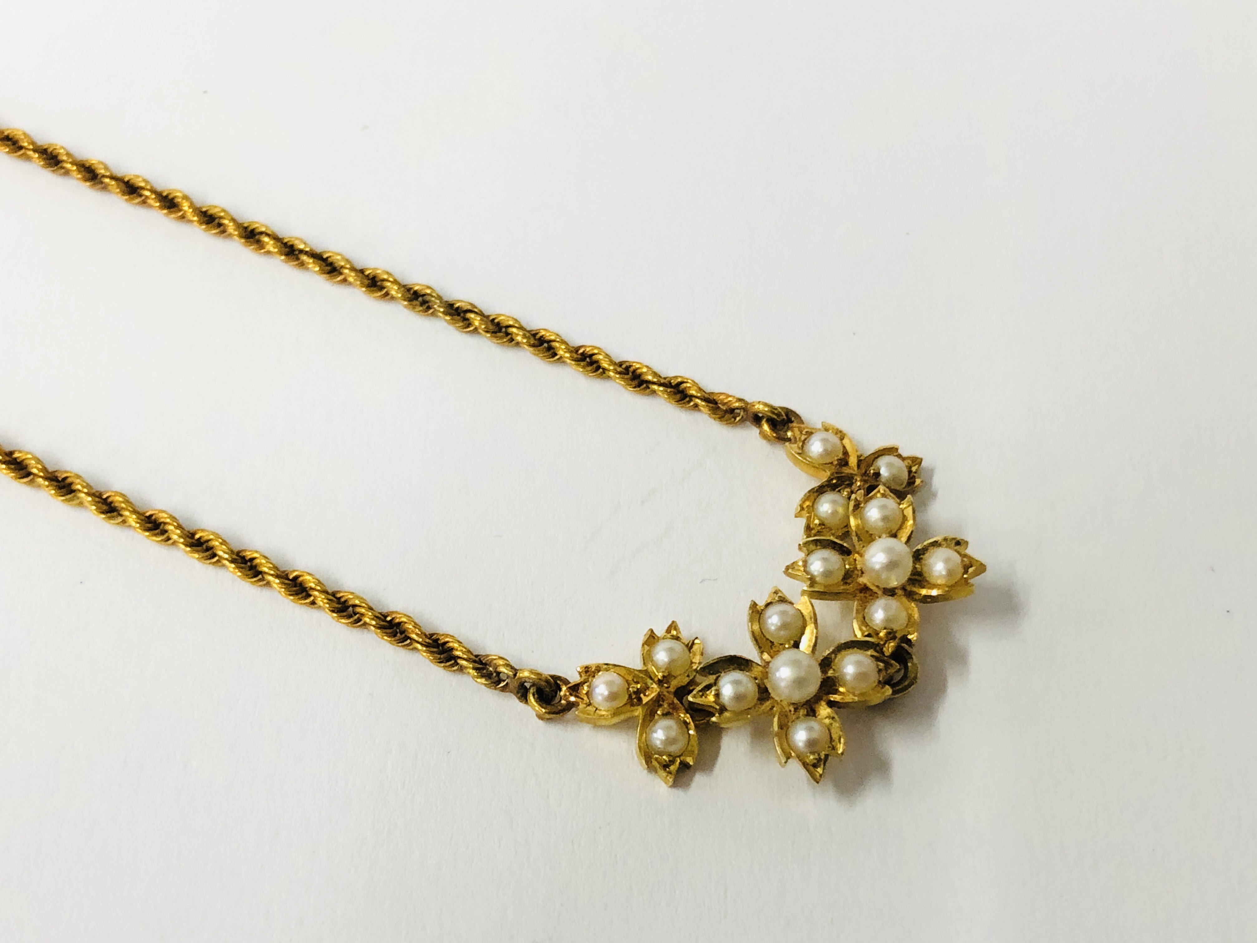 AN ANTIQUE CHILD'S YELLOW METAL ROPE DESIGN NECKLACE SET WITH SEED PEARLS, LENGTH 31CM.
