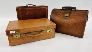 A VINTAGE TAN LEATHER CASE WITH BRASS FITTINGS AND CONCEALED INTERIOR WRITING SURFACE ALONG WITH A