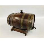 AN OAK BRASS BOUND SPIRIT BARREL ON STAND - LENGTH 47CM. HEIGHT 23CM.