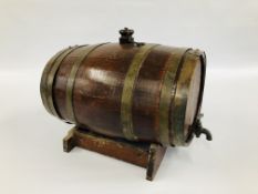 AN OAK BRASS BOUND SPIRIT BARREL ON STAND - LENGTH 47CM. HEIGHT 23CM.