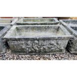 A PAIR OF HEAVY RECTANGULAR STONEWORK PLANTING TROUGHS WITH RELIEF CHERUB DECORATION. W 88CM.