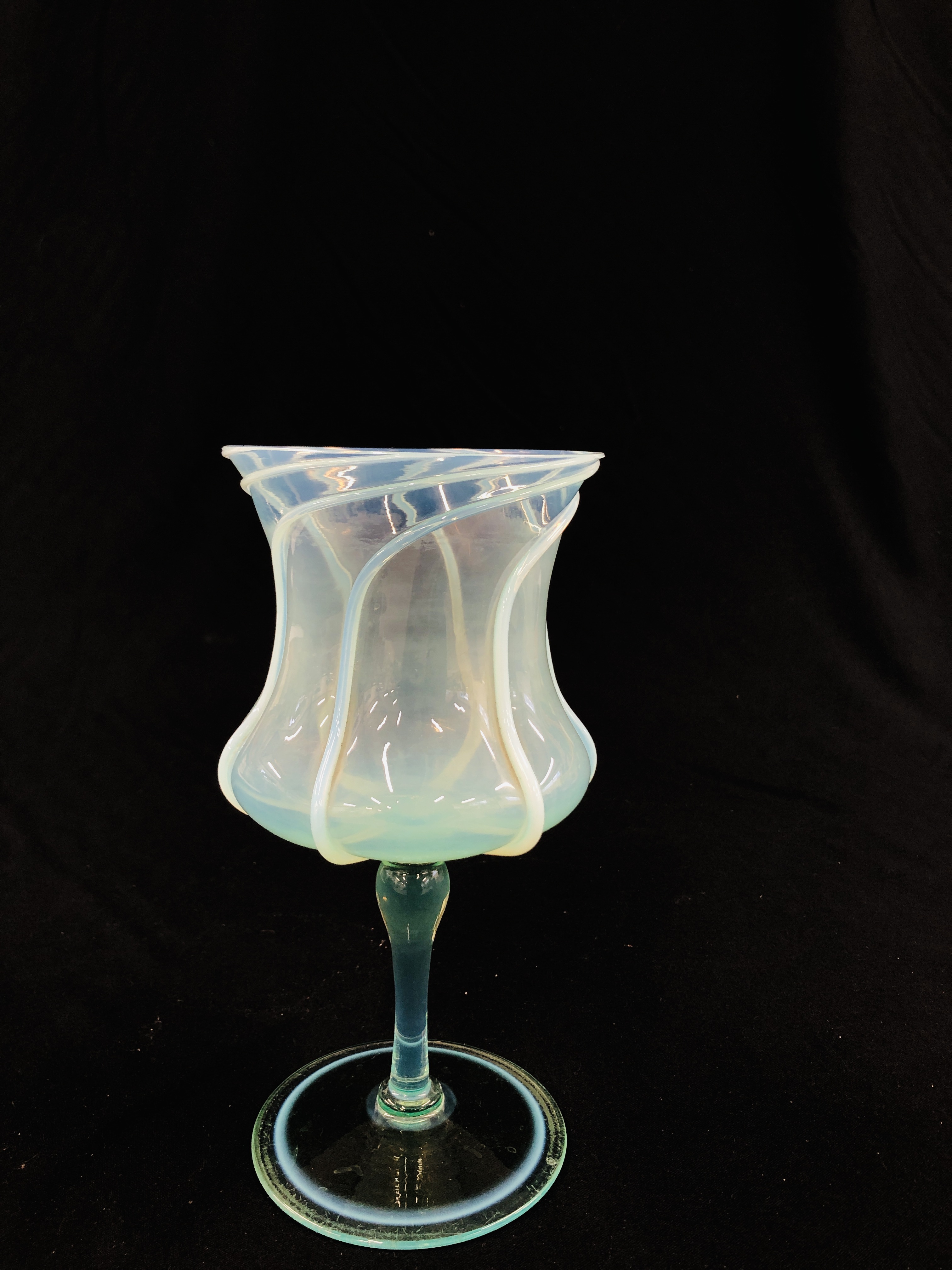 A VENETIAN GOBLET, PALE GREEN WITH SPIRAL OVERLAY ON THE THISTLE SHAPED BOWL, 23CM HIGH.