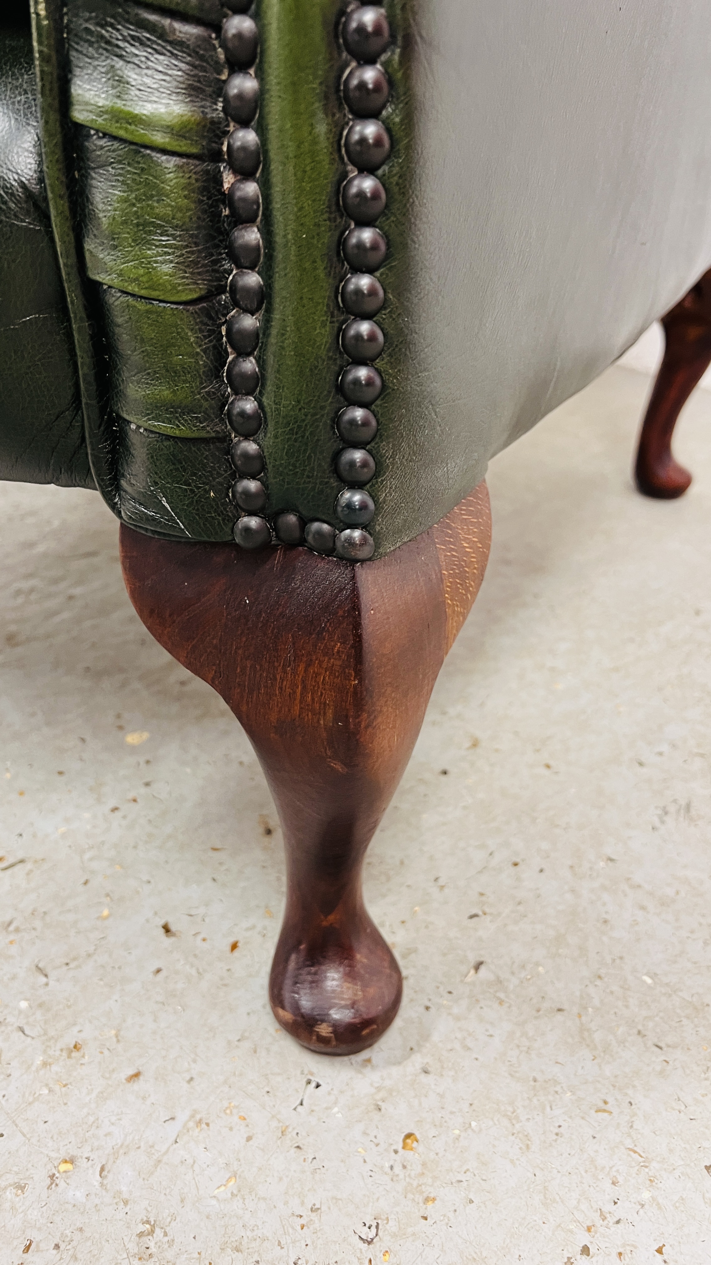 A BOTTLE GREEN LEATHER BUTTON BACK WING CHAIR - FRONT LEG A/F. - Image 9 of 10