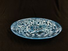 A CIRCULAR DISH, THE BLUE GLASS WITH DAPPLED DECORATION UNSIGNED - 45CM. DIAMETER.