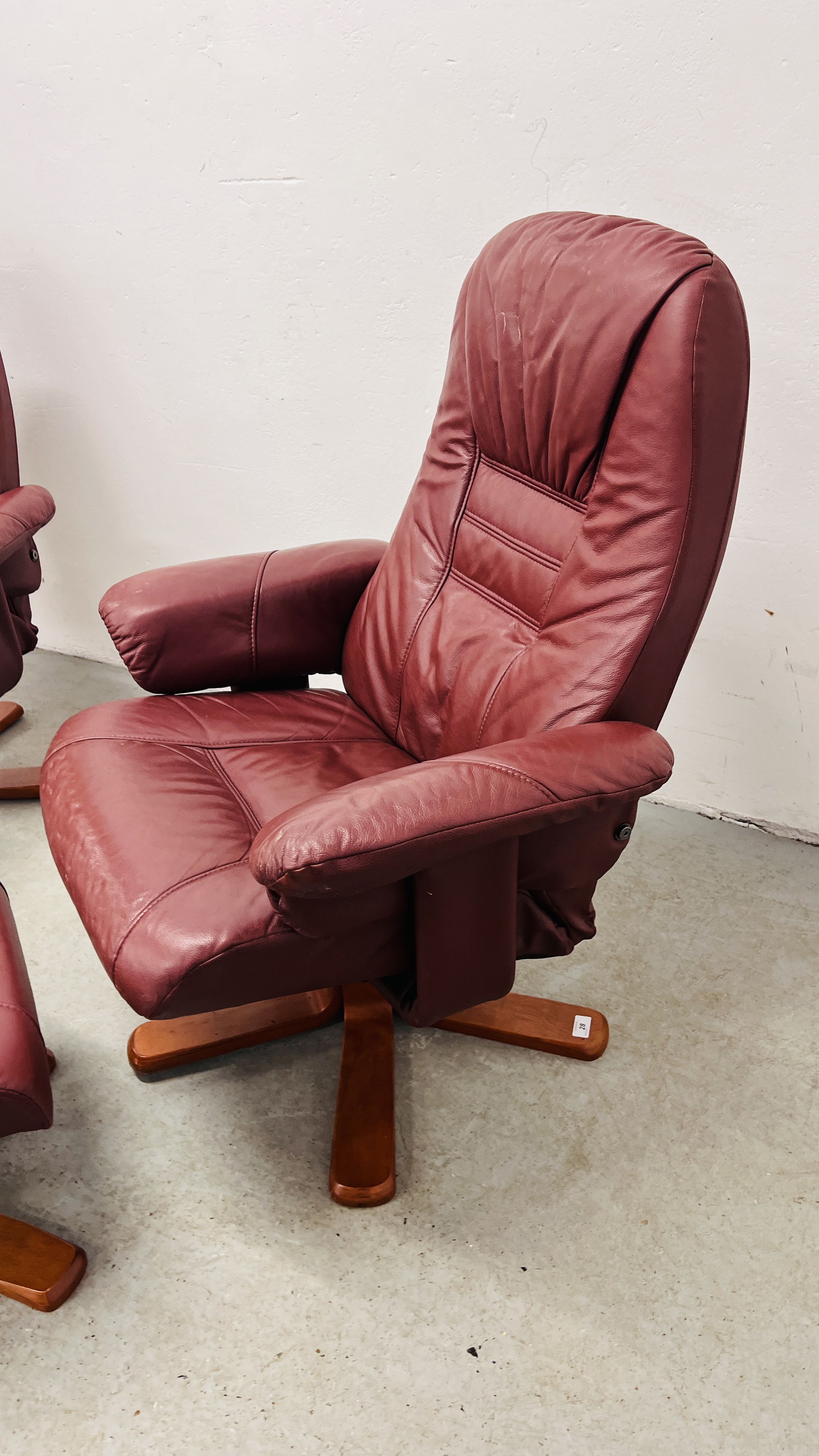 A PAIR OF RED LEATHER REVOLVING ARMCHAIRS WITH FOOTSTOOLS. - Image 14 of 25