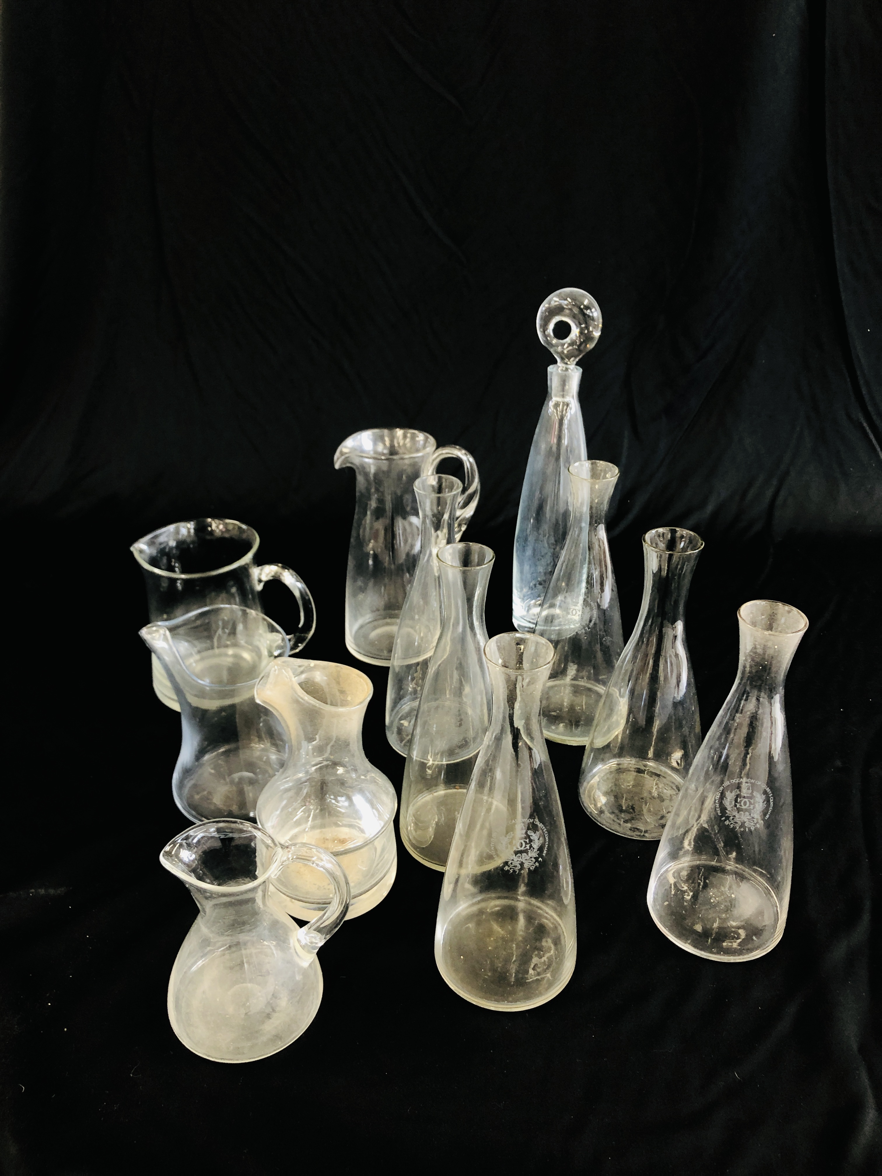 A GROUP OF GLASSWARE TO INCLUDE VARIOUS CLEAR GLASS WATER JUGS,